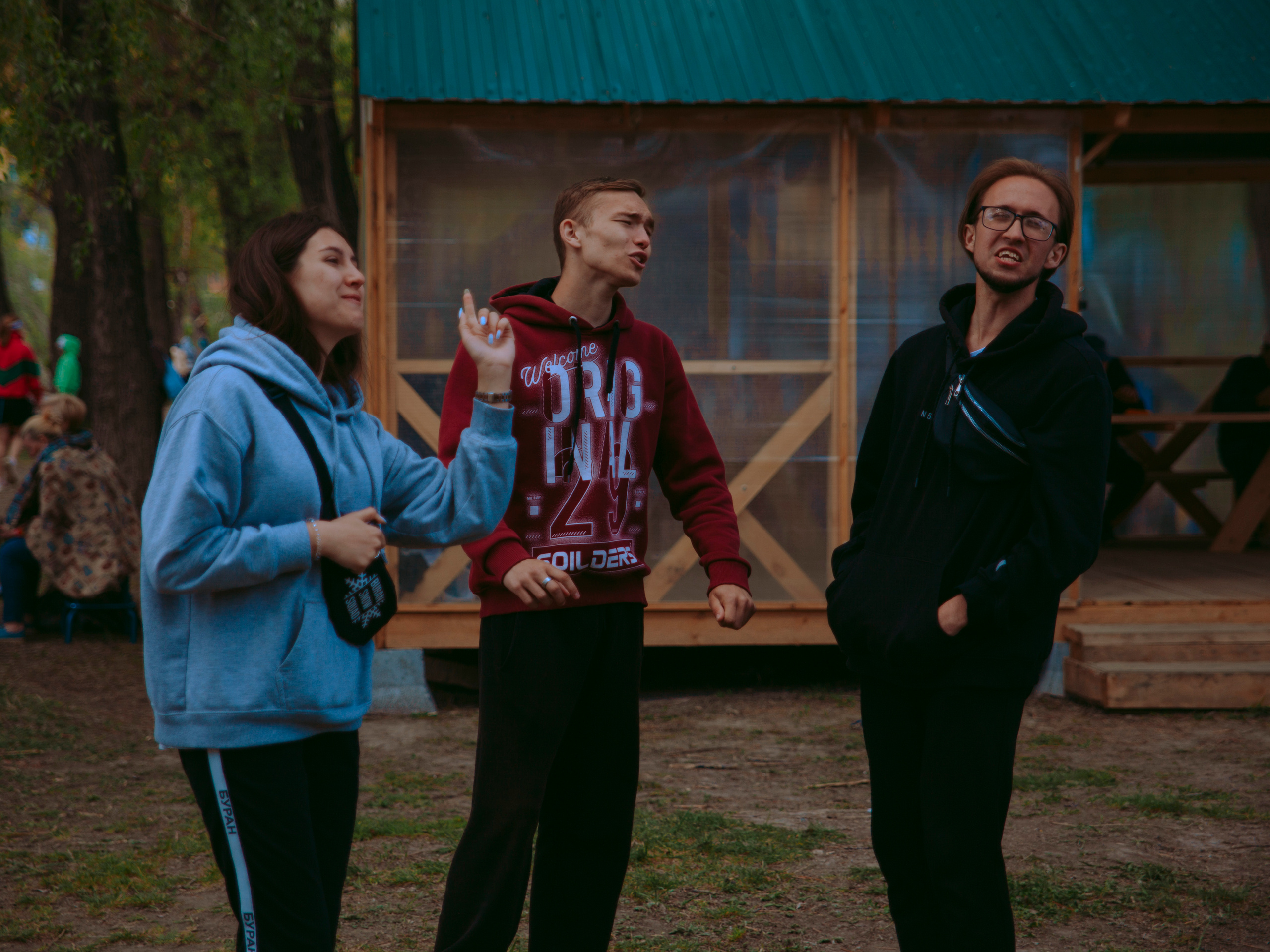 Молодые люди танцуют в парке.