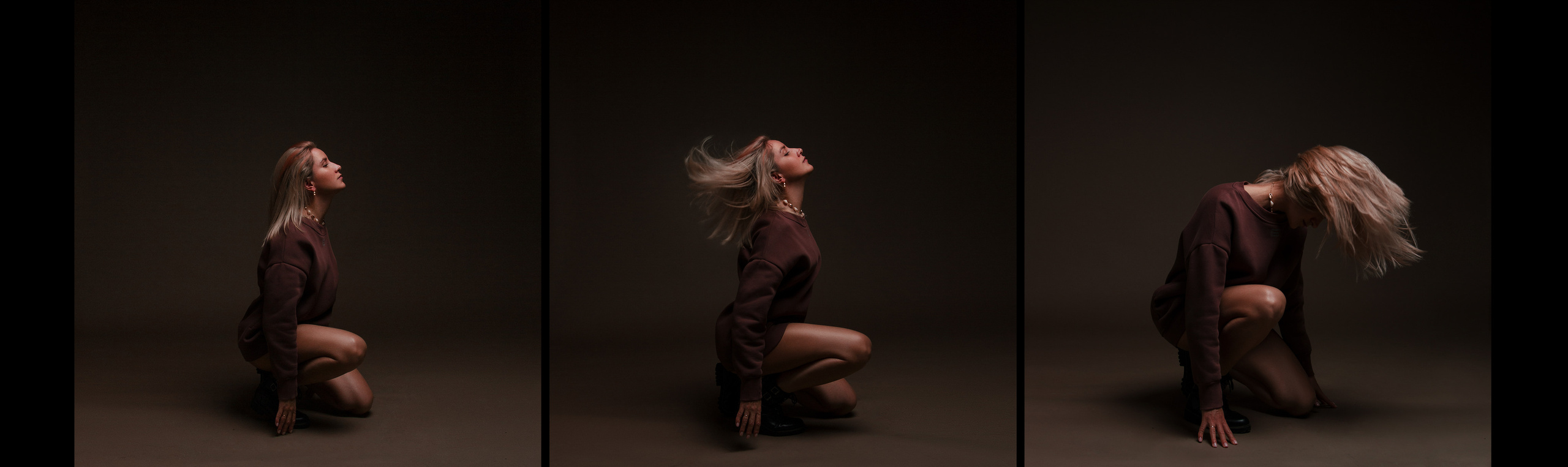 Девушка в бордовой худи сидит на коленях и машет волосами.