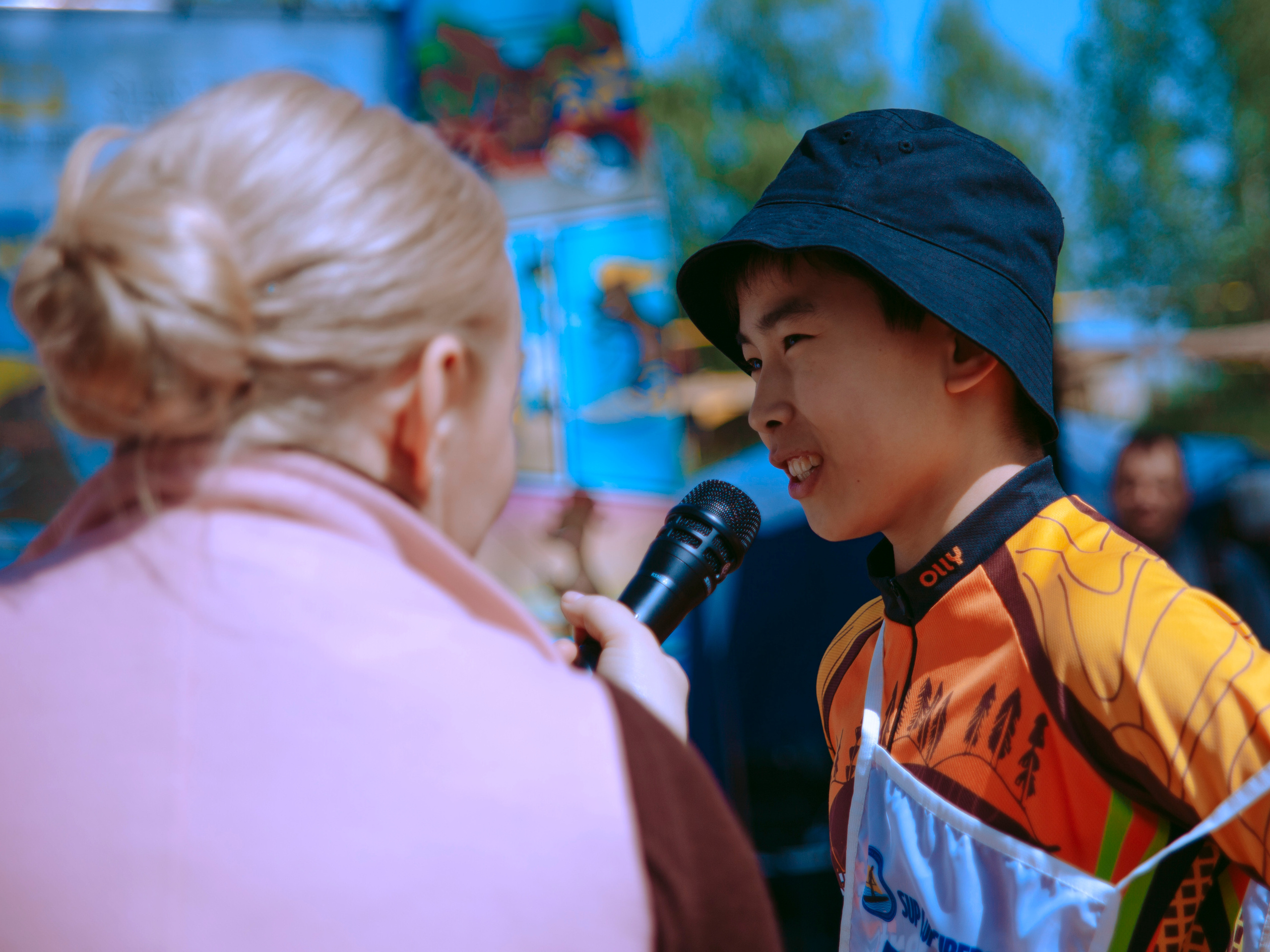 Азиатский мальчик говорит в микрофон.