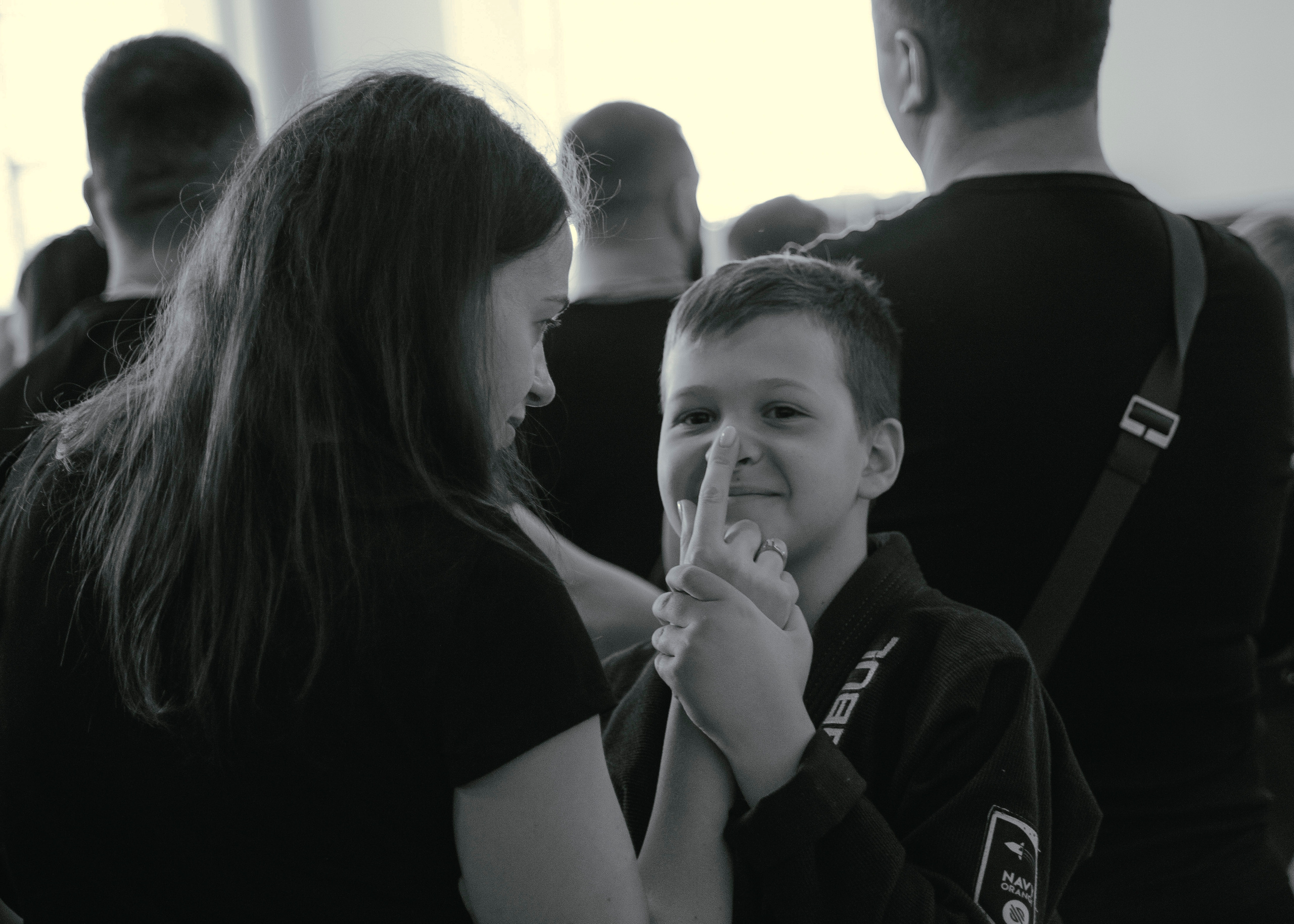 Мама играет с сыном и трогает его за нос.