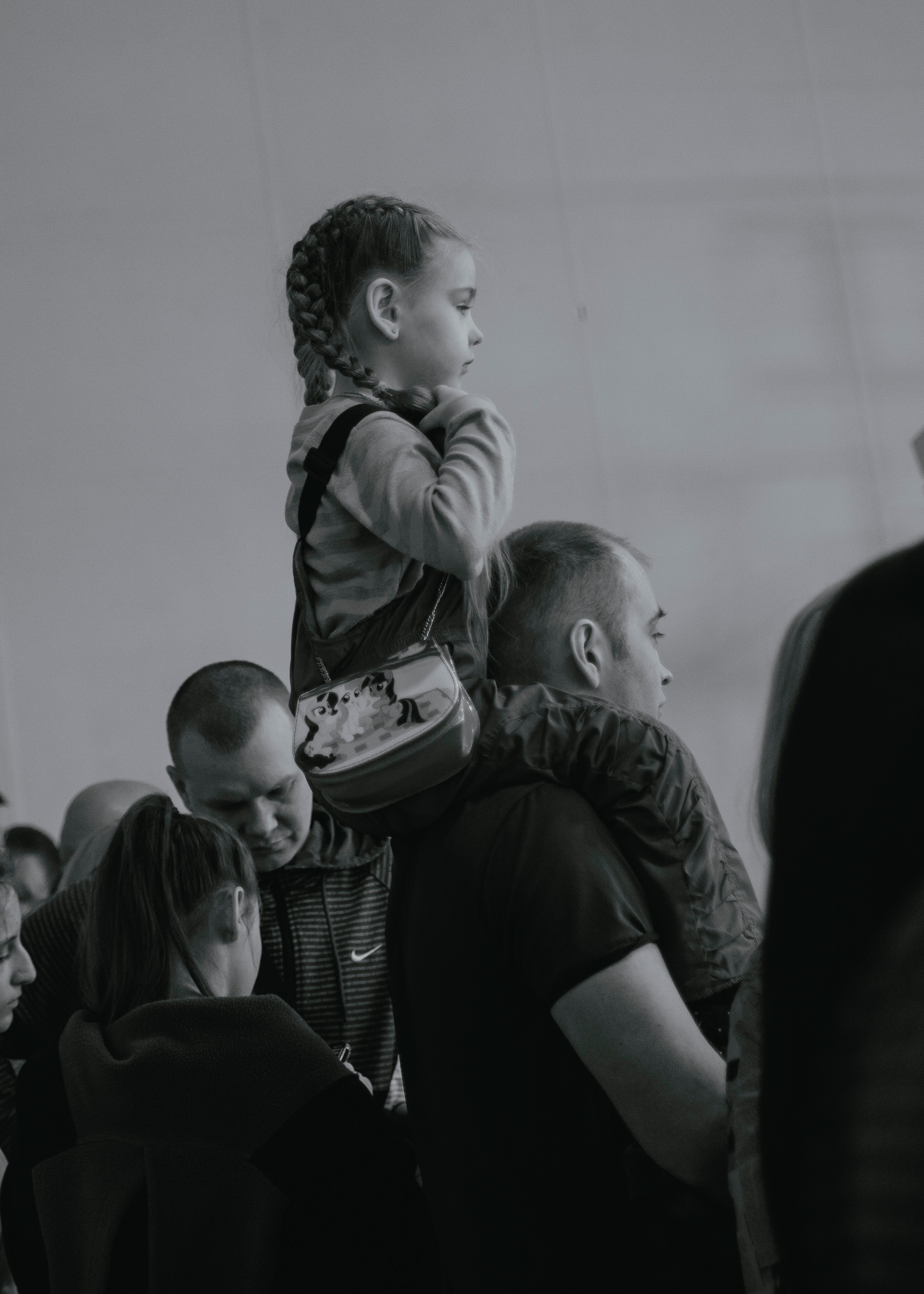 Дочь сидит на плечах у папы на соревнованиях.