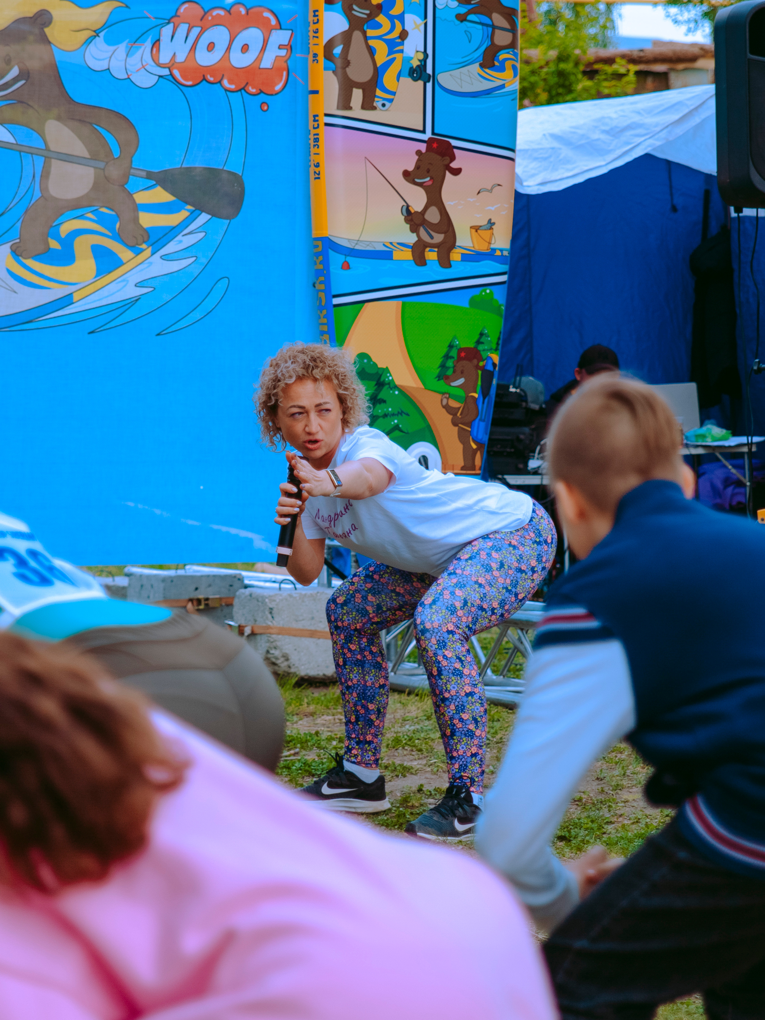 Женщина тренер проводит тренировку на свежем воздухе на фестивале по сап-серфингу.