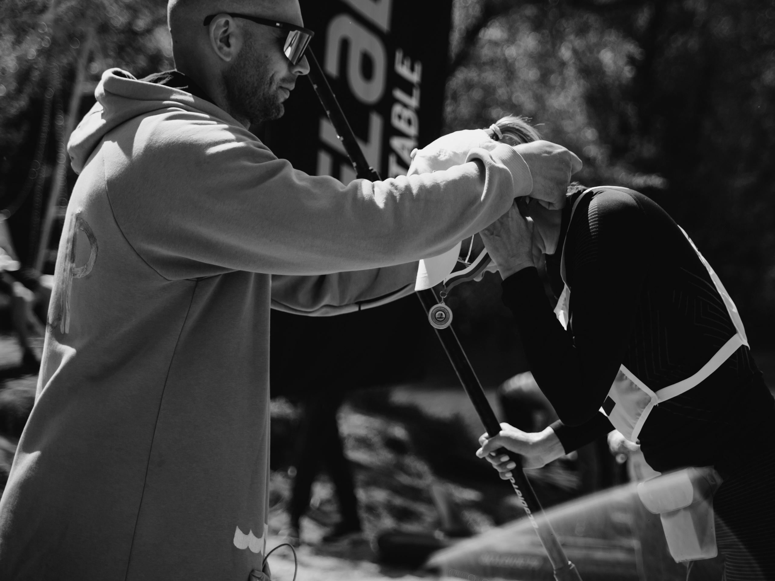 Тренер надевает на женщину медаль.