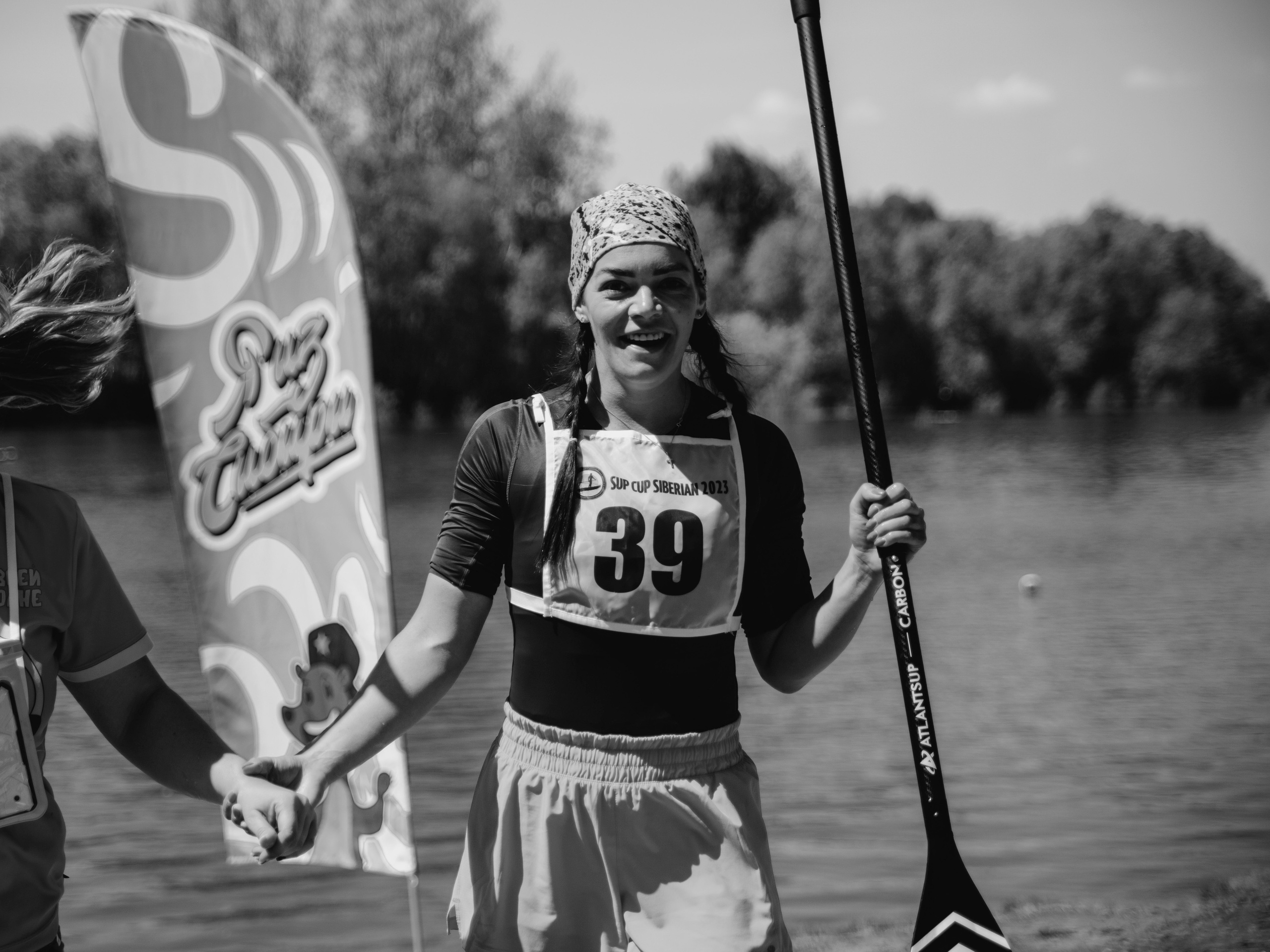 Девушка с веслом улыбается чб.