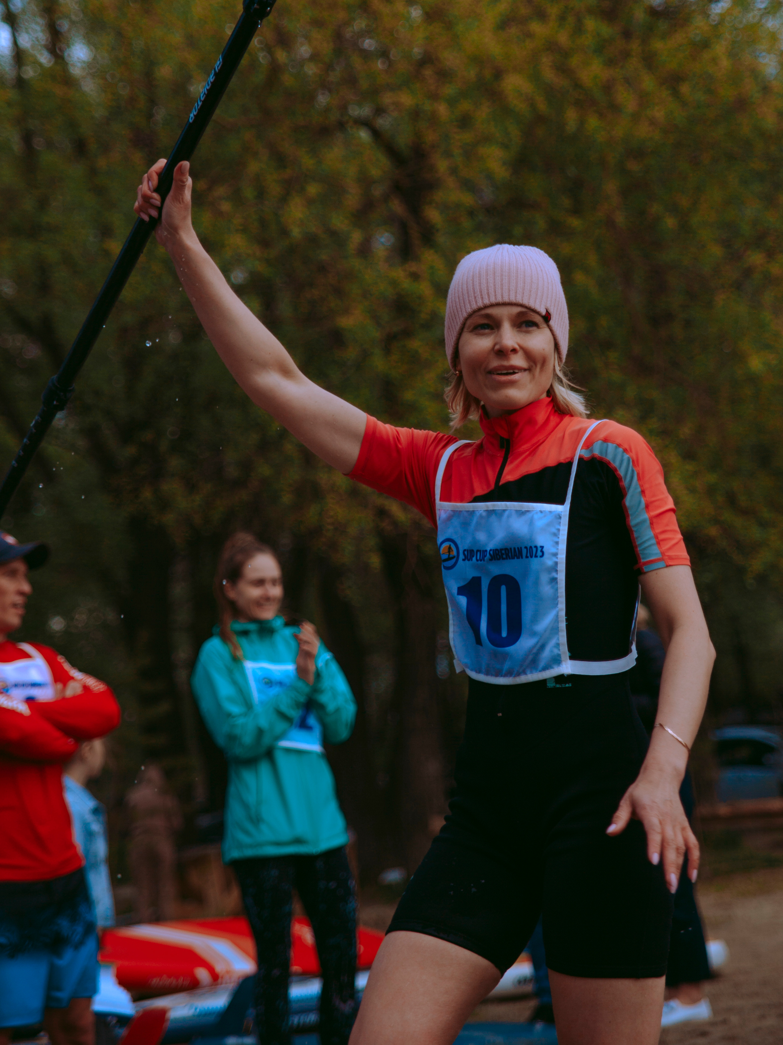 Девушка поднимает весло.