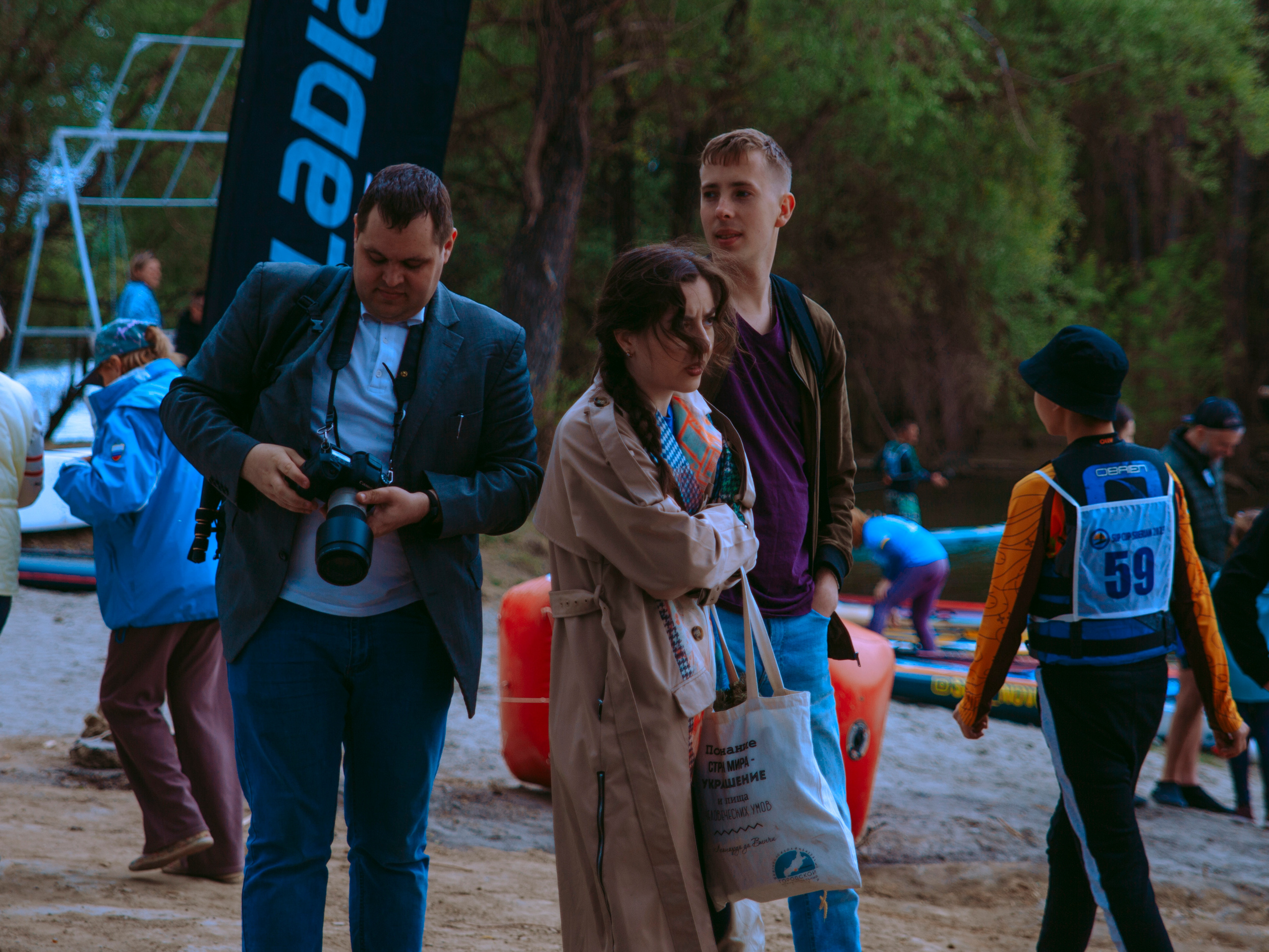 Человек с фотоаппаратом идет по берегу.