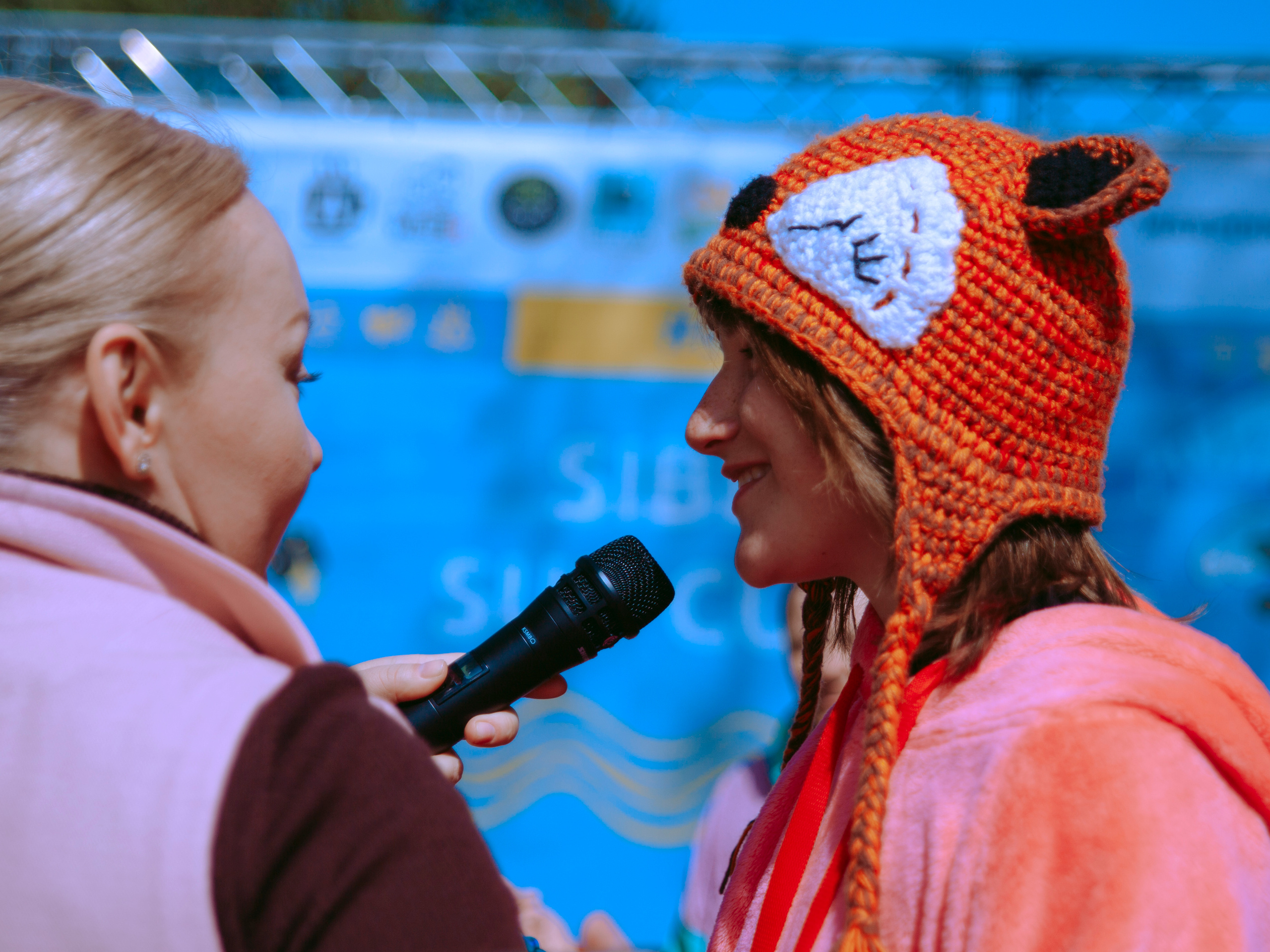 Девочка в лисьей шапке говорит в микрофон.