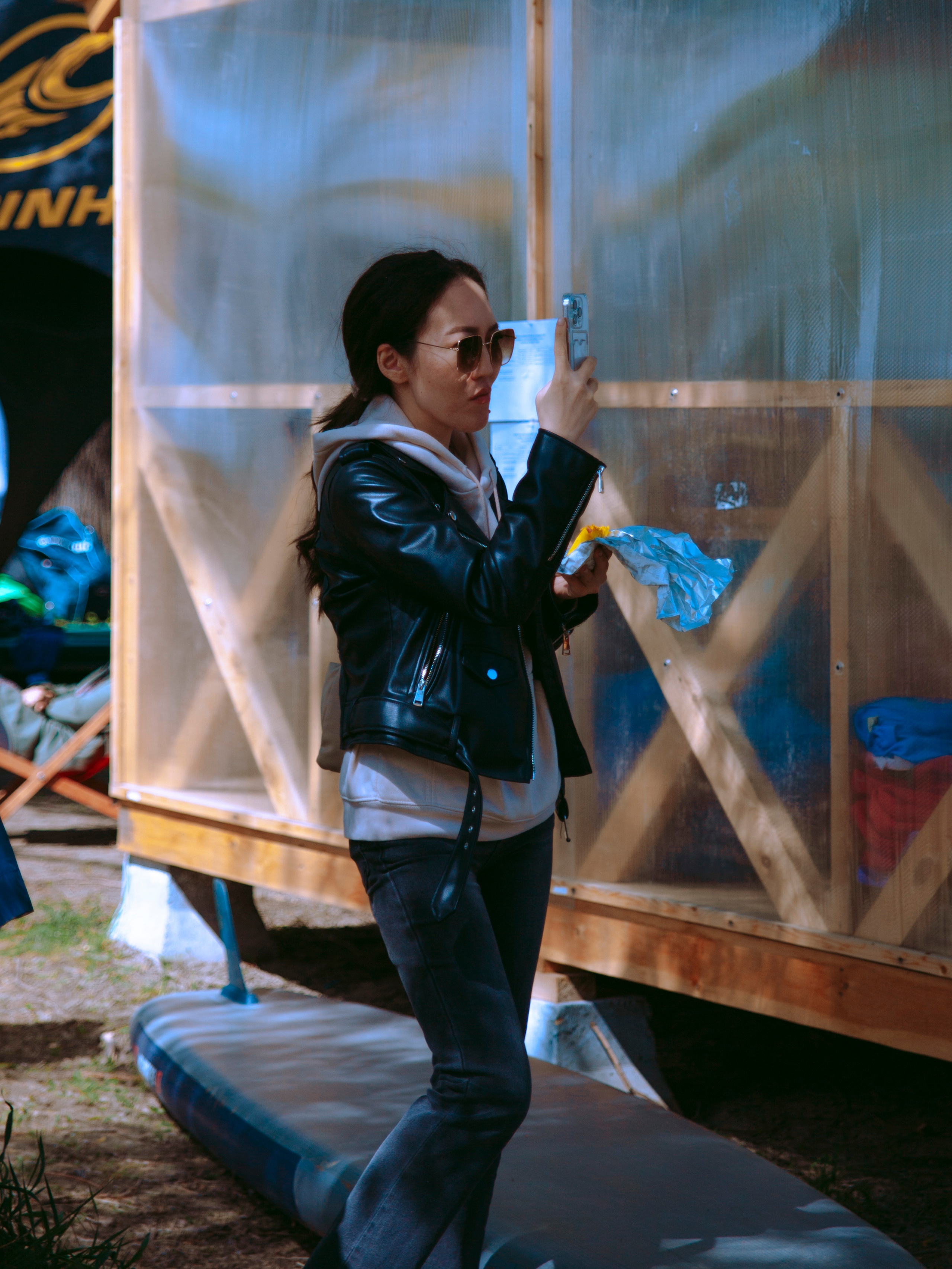 Азиатская девушка снимает на телефон.