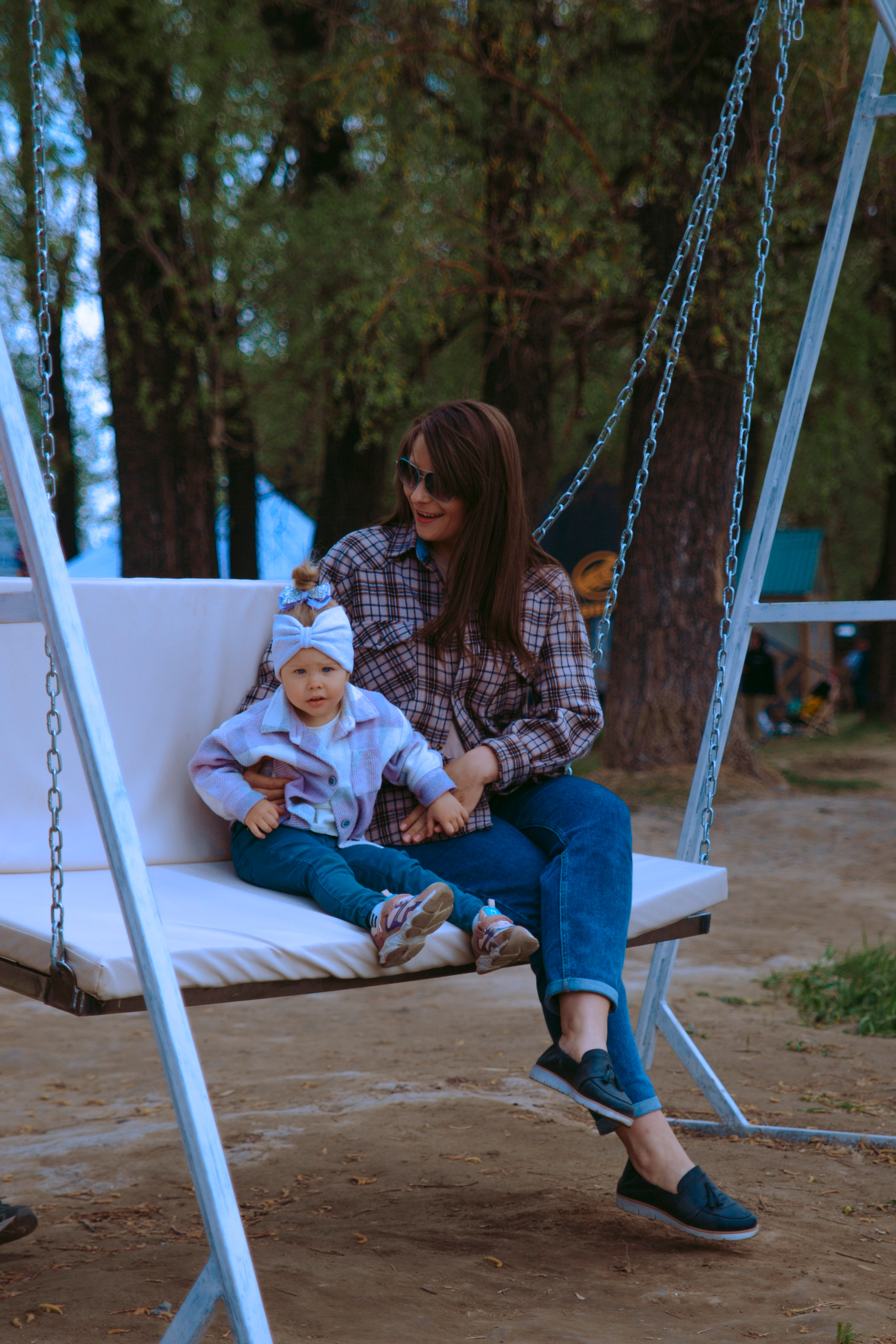 Мама с маленькой дочкой на качелях.