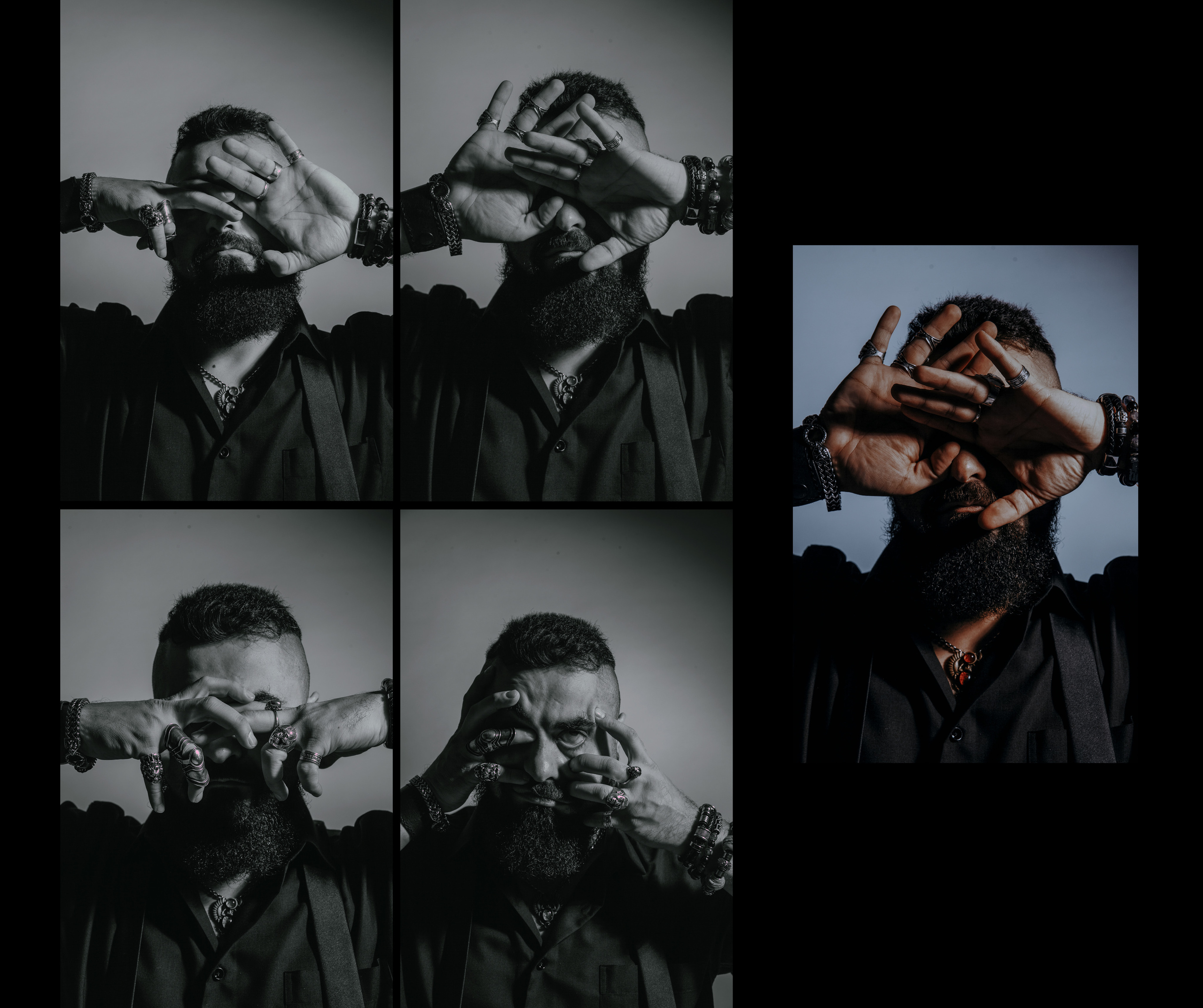 Восточный брутальный мужчина художник с большим количеством украшений трогает лицо руками, закрывает глаза руками.