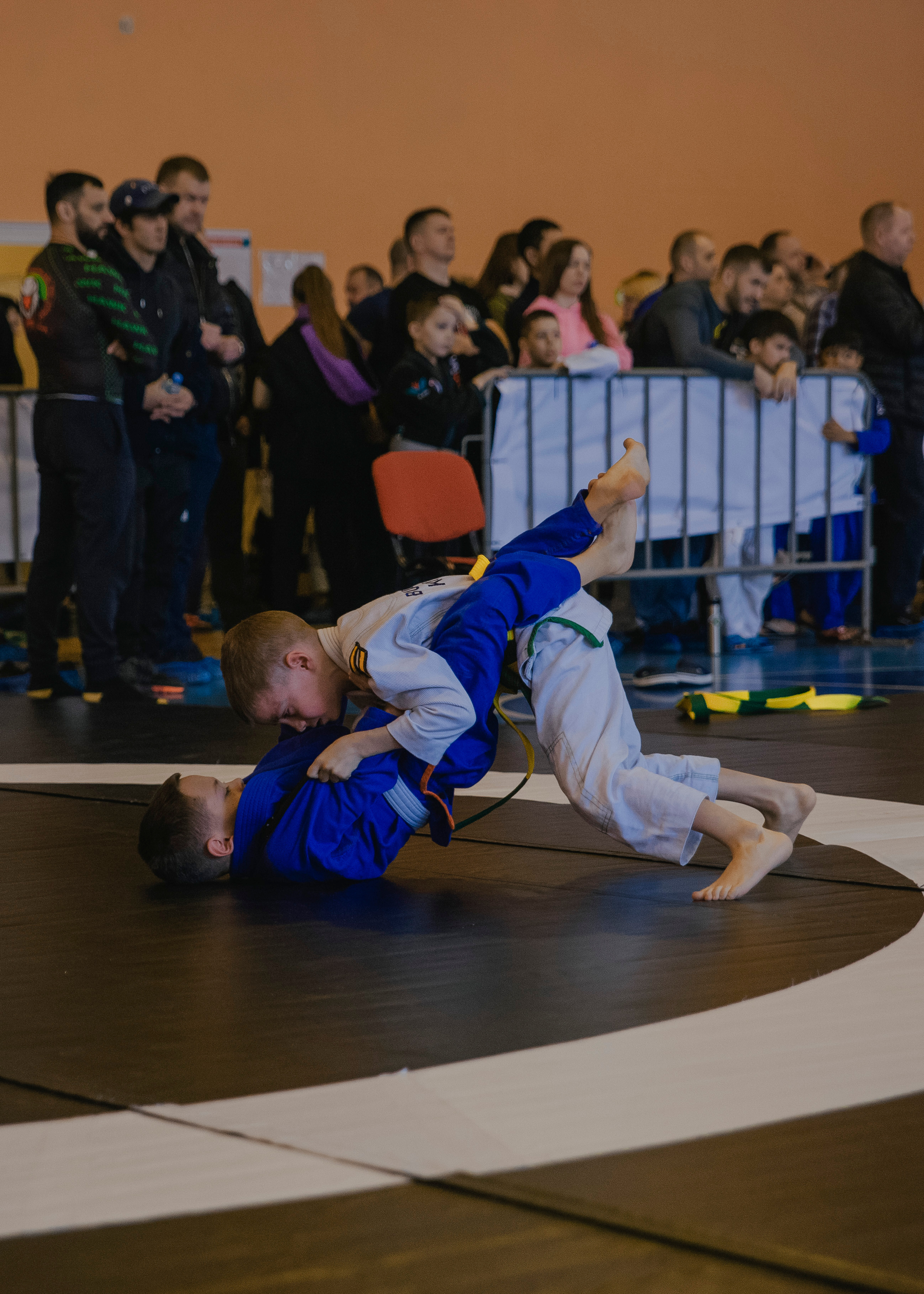 Борьба в кимоно gi на детском турнире по джиу-джитсу.