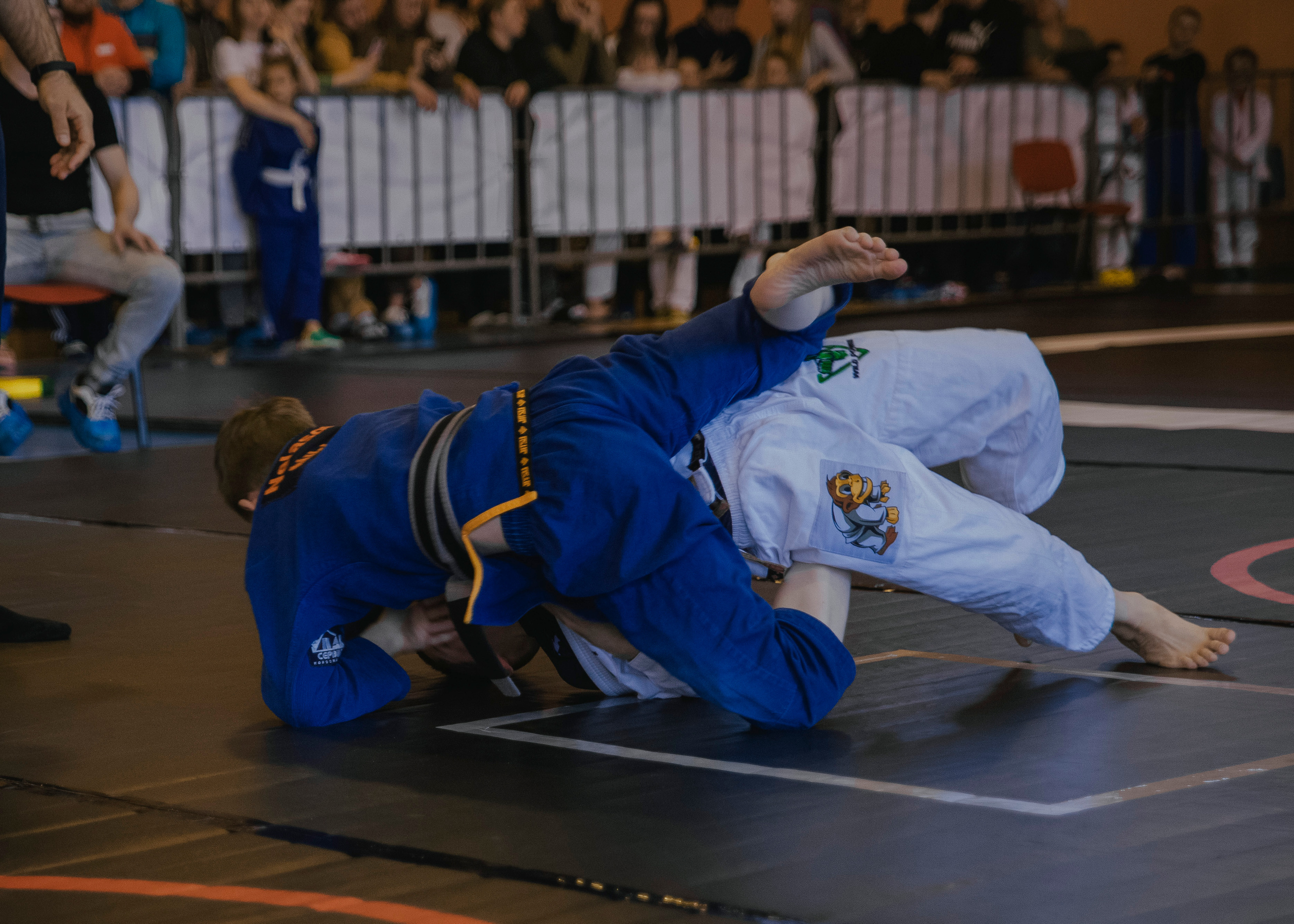 Борьба в кимоно gi на детском турнире по джиу-джитсу.