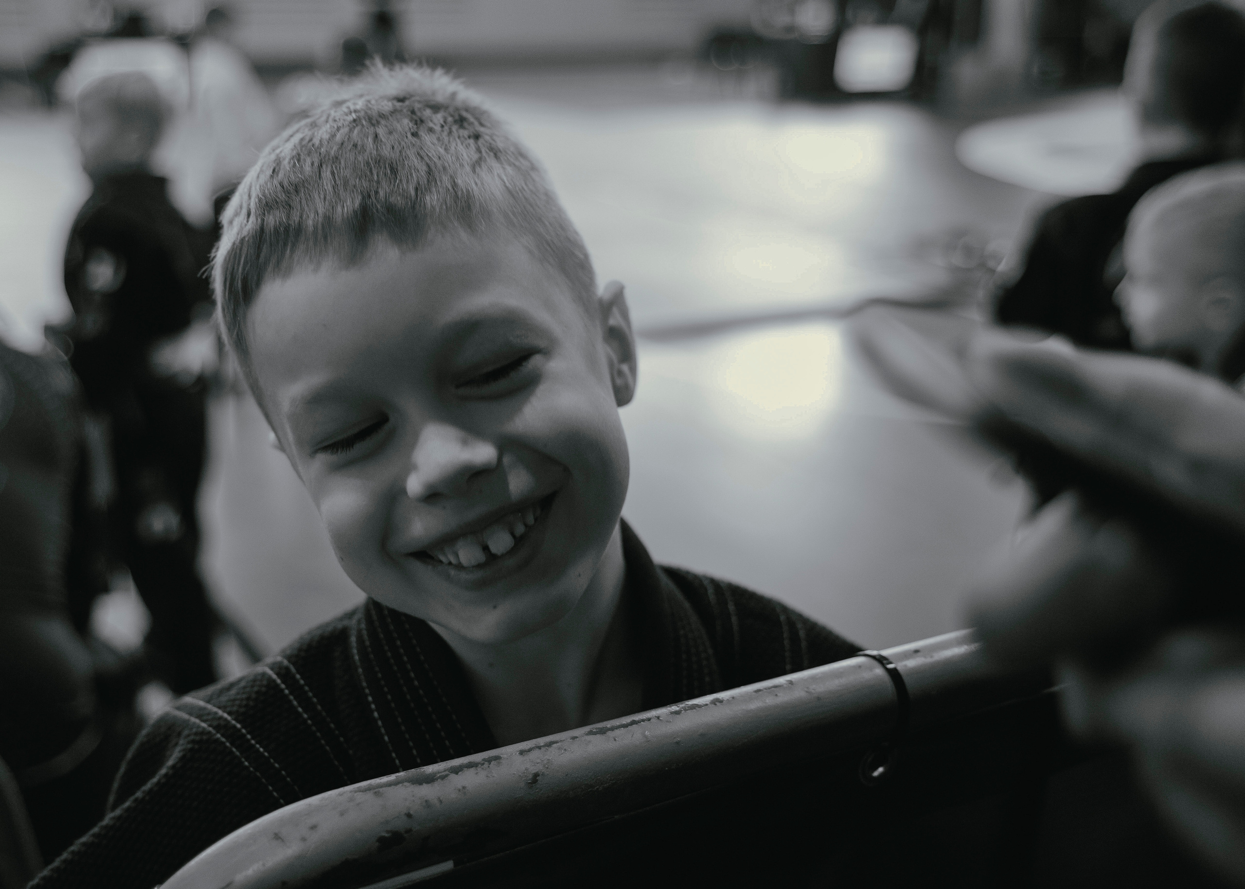 Ребенок улыбается крупным планом на детском турнире по джиу-джитсу.