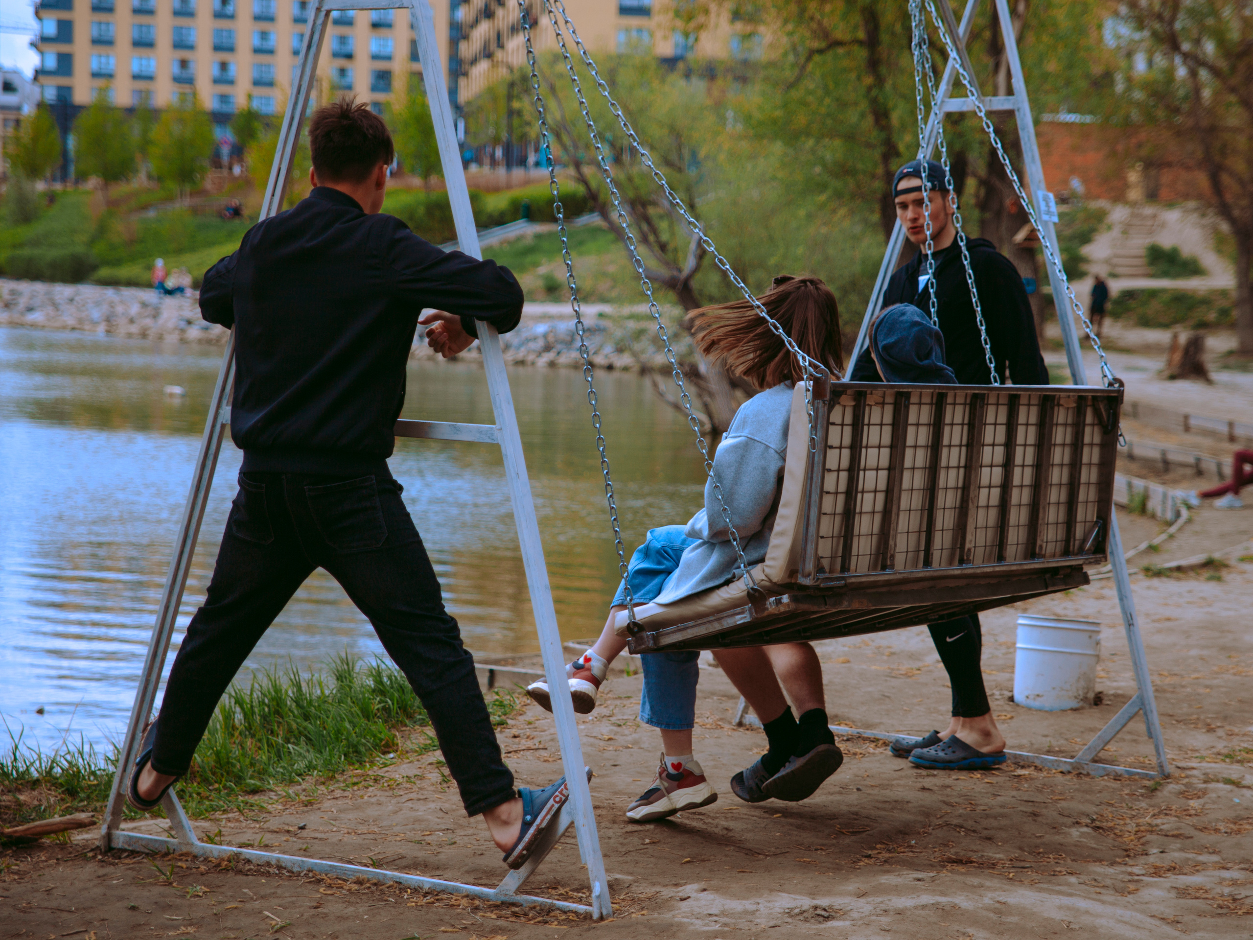 Молодые парни флиртуют с девушками в парке.