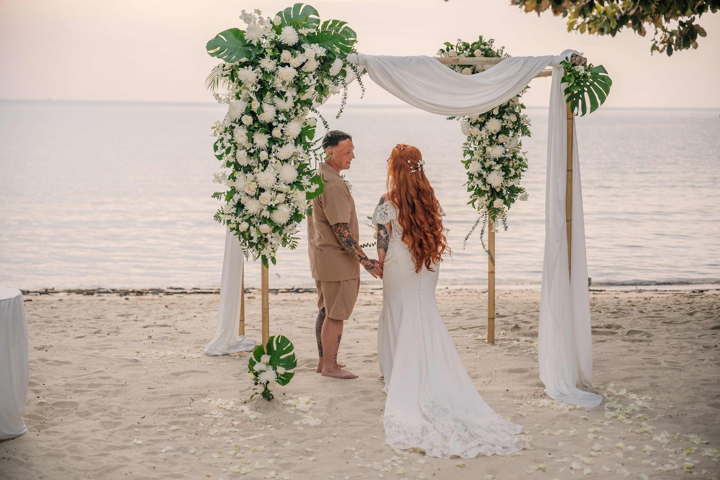 Bride and groom during a romantic beach wedding ceremony on Koh Samui, Thailand, surrounded by tropical scenery and ocean views