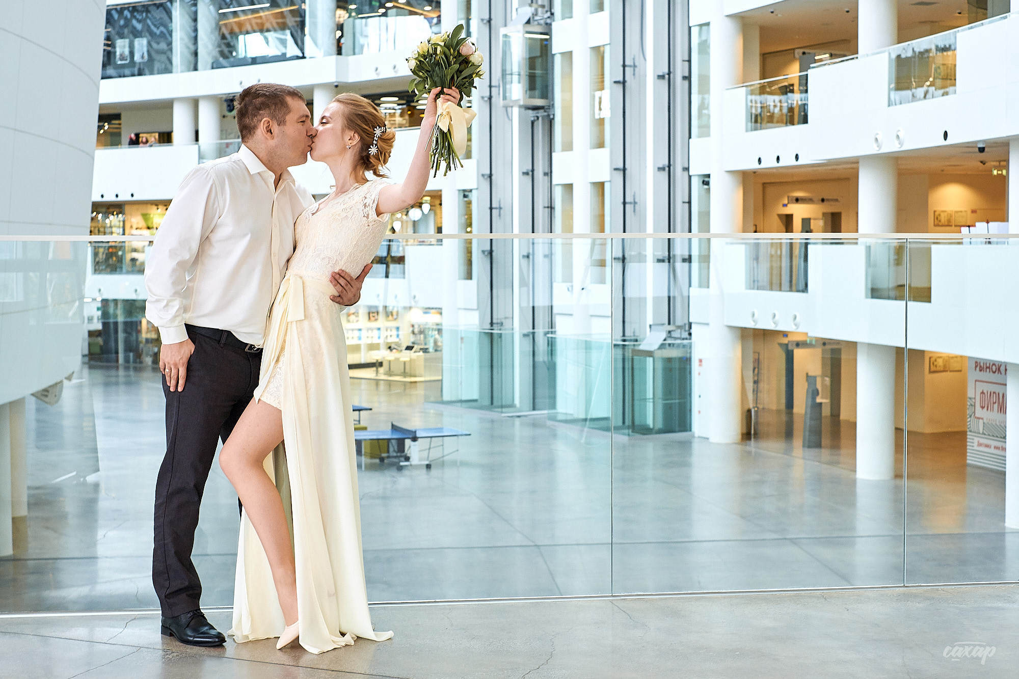 жених и невеста со свадебным букетом в танце целуются