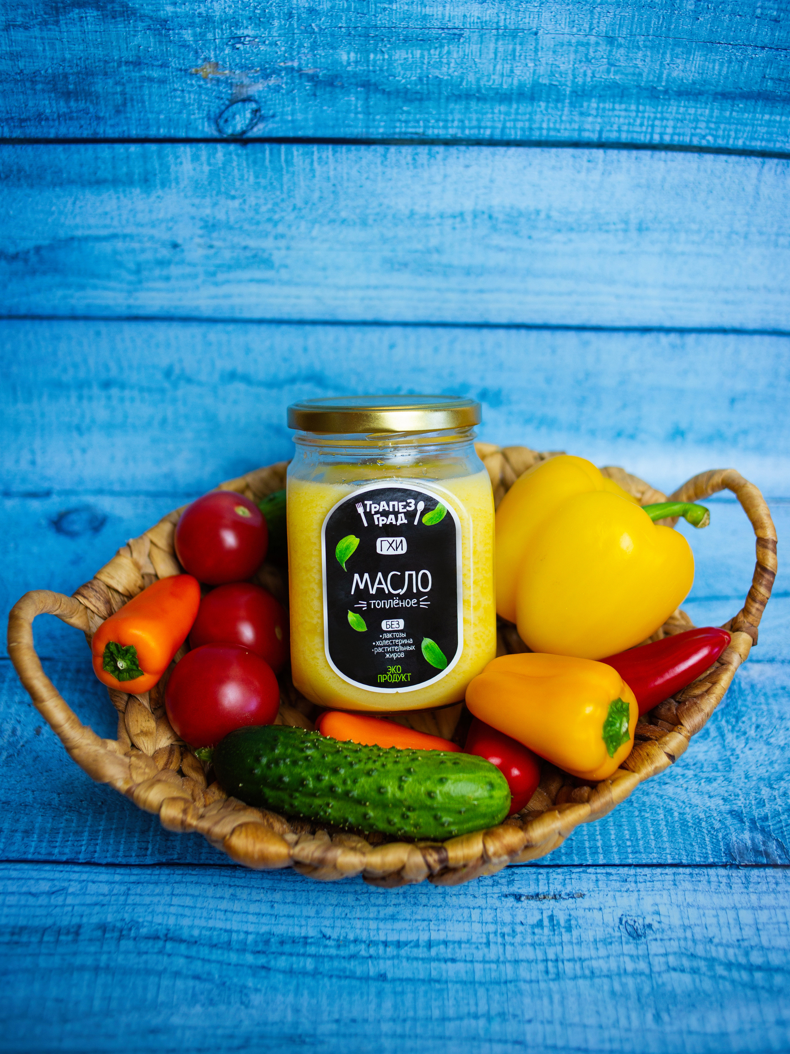 на столе стоит корзинка  в  ней овощи  и  банка  топленного масла