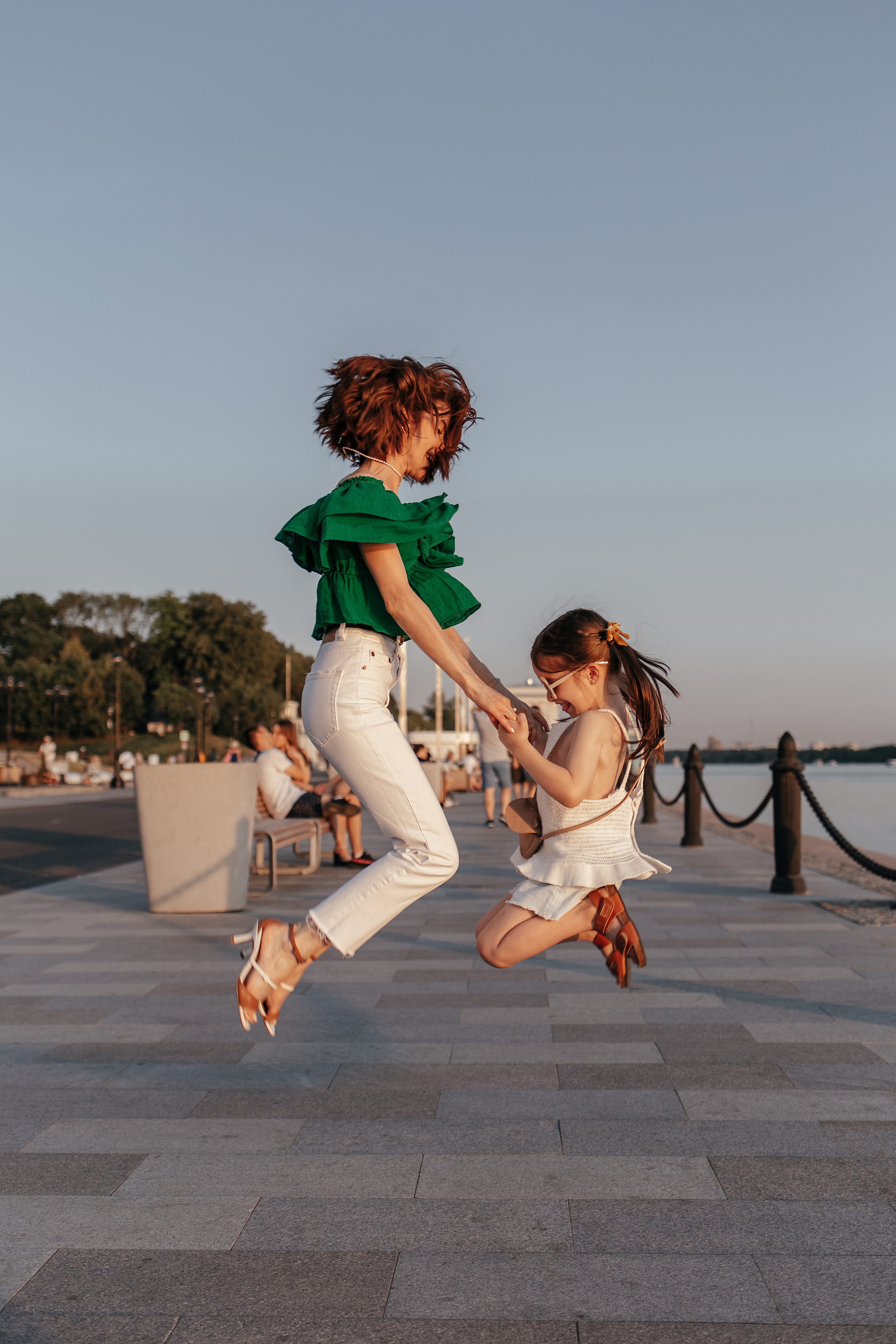 Мама и дочь прыгают, держась за руки, на прогулке в летнем парке Москвы. Семейная фотосессия в парке. Прогулочная фотосессия в Москве. Семейный фотограф. Фотосессия в Москве. Фотосессия в Видном. Фотограф Москва. Фотограф Видное. Свадебный и семейный фотограф. Душевный фотограф. Красивые фотографии прогулок. Заказать фотосессию. 