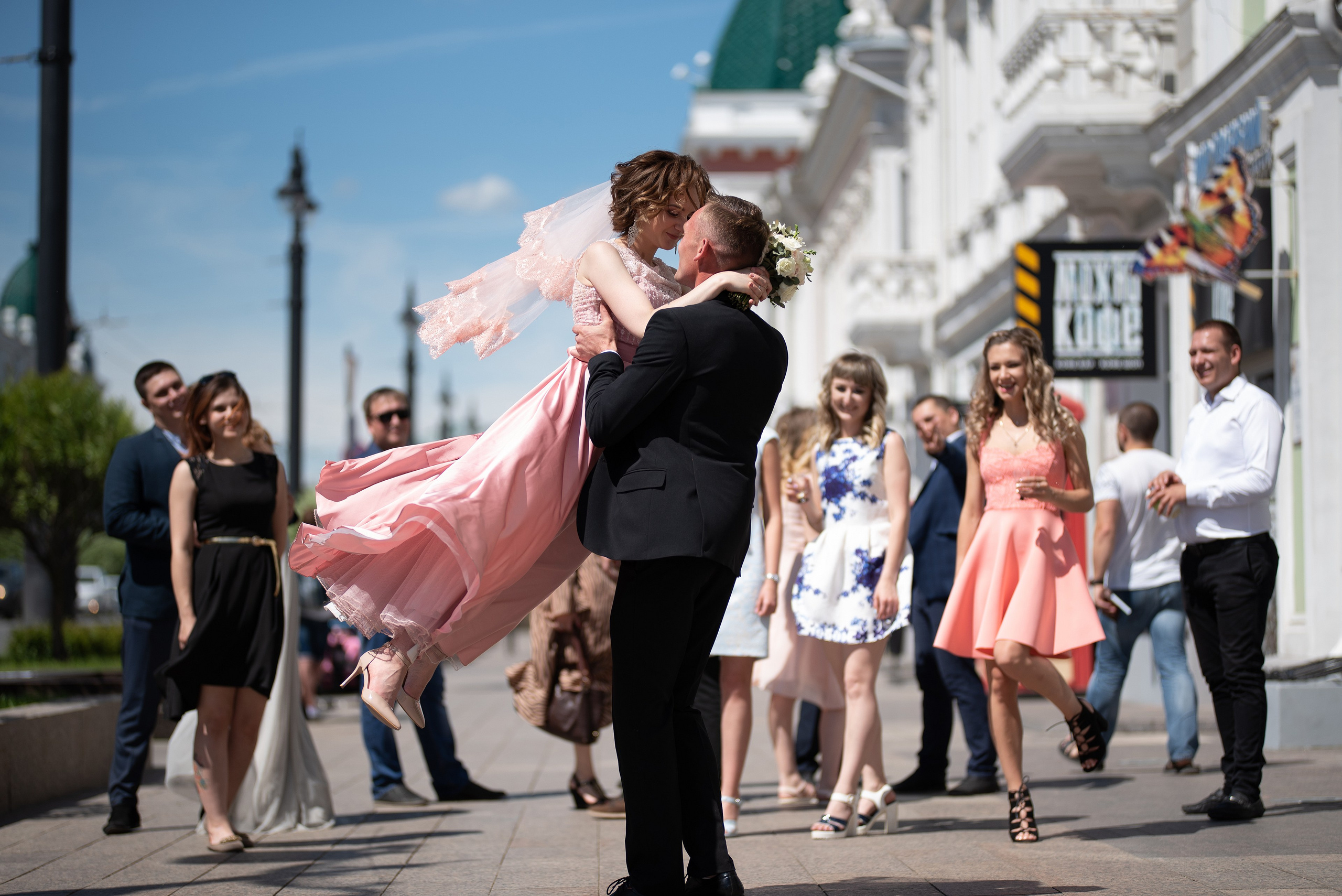 Жених кружит невесту на руках.