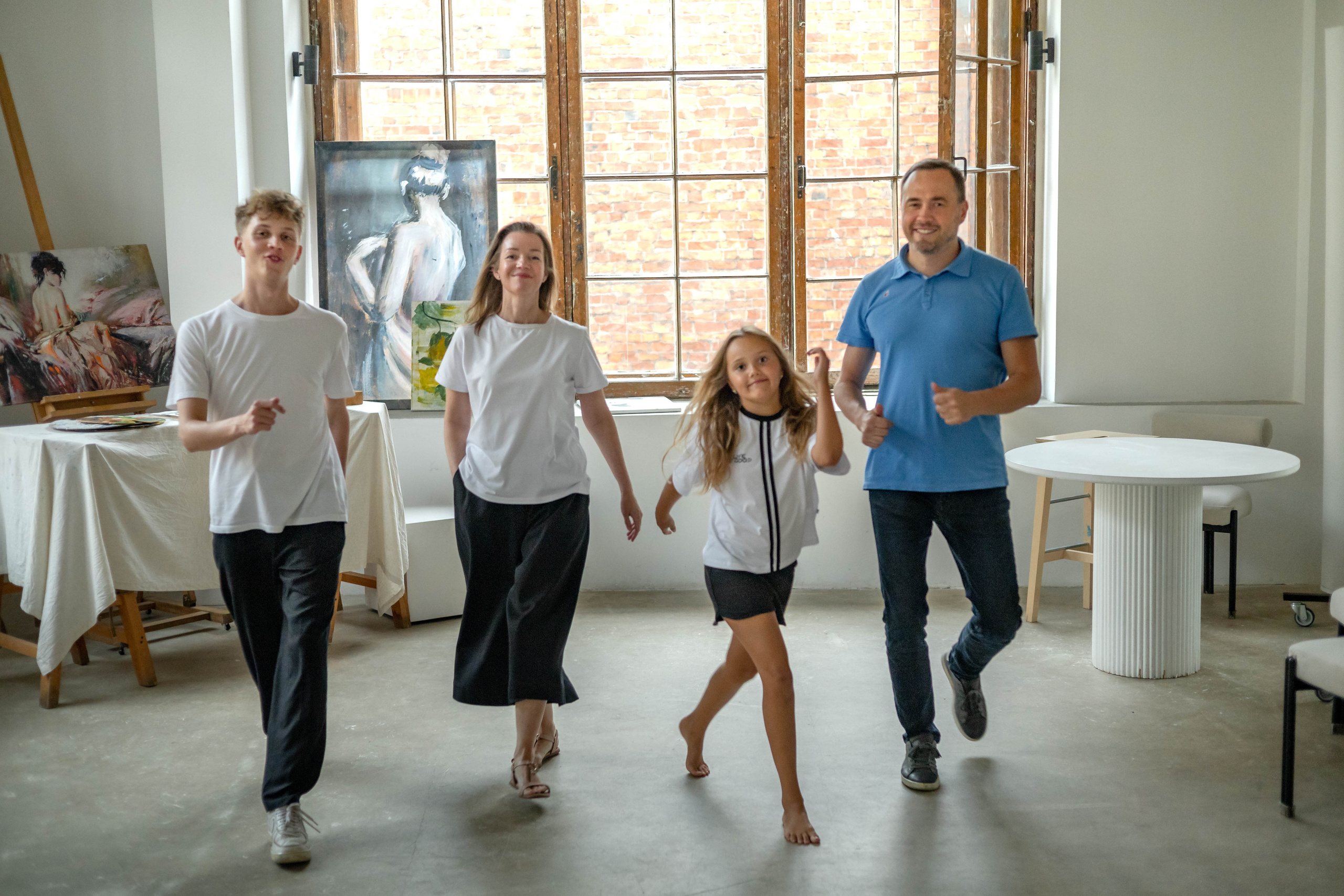 Семья из четырех человек идет по комнате