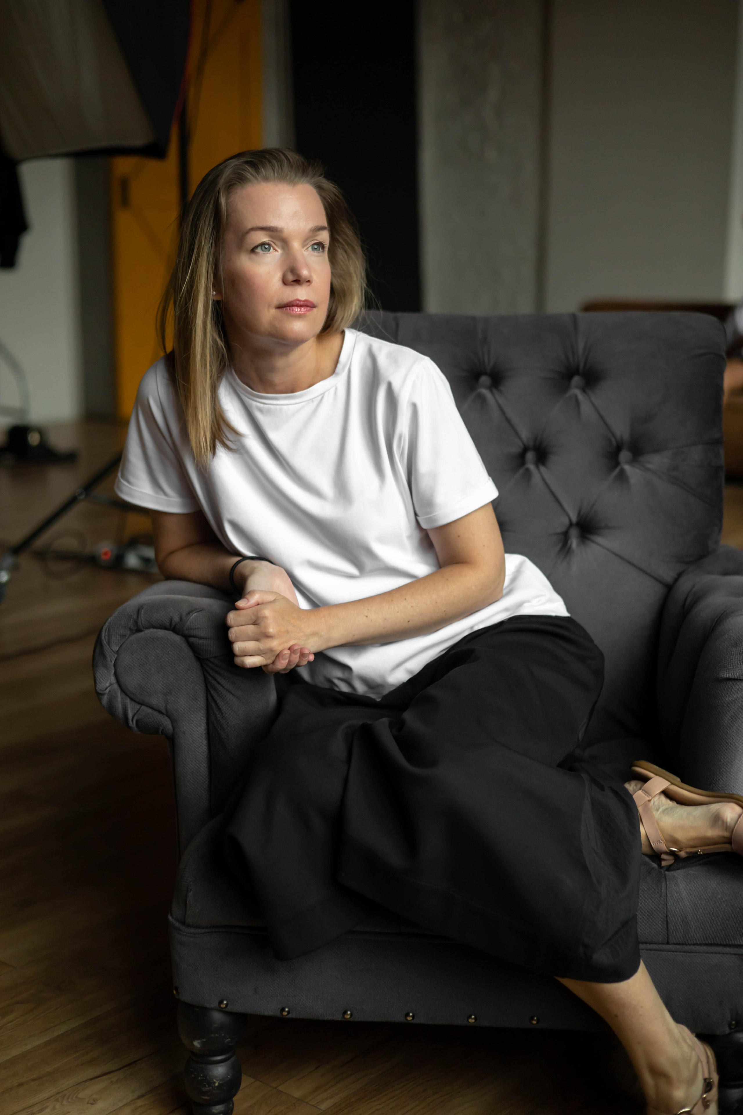 Женщина сидит в кресле и смотрит в окно