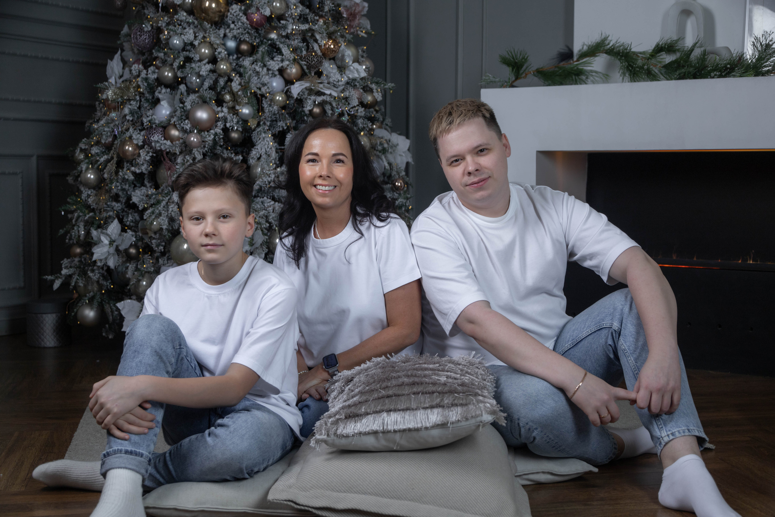 Мама и два сына сидят у елки