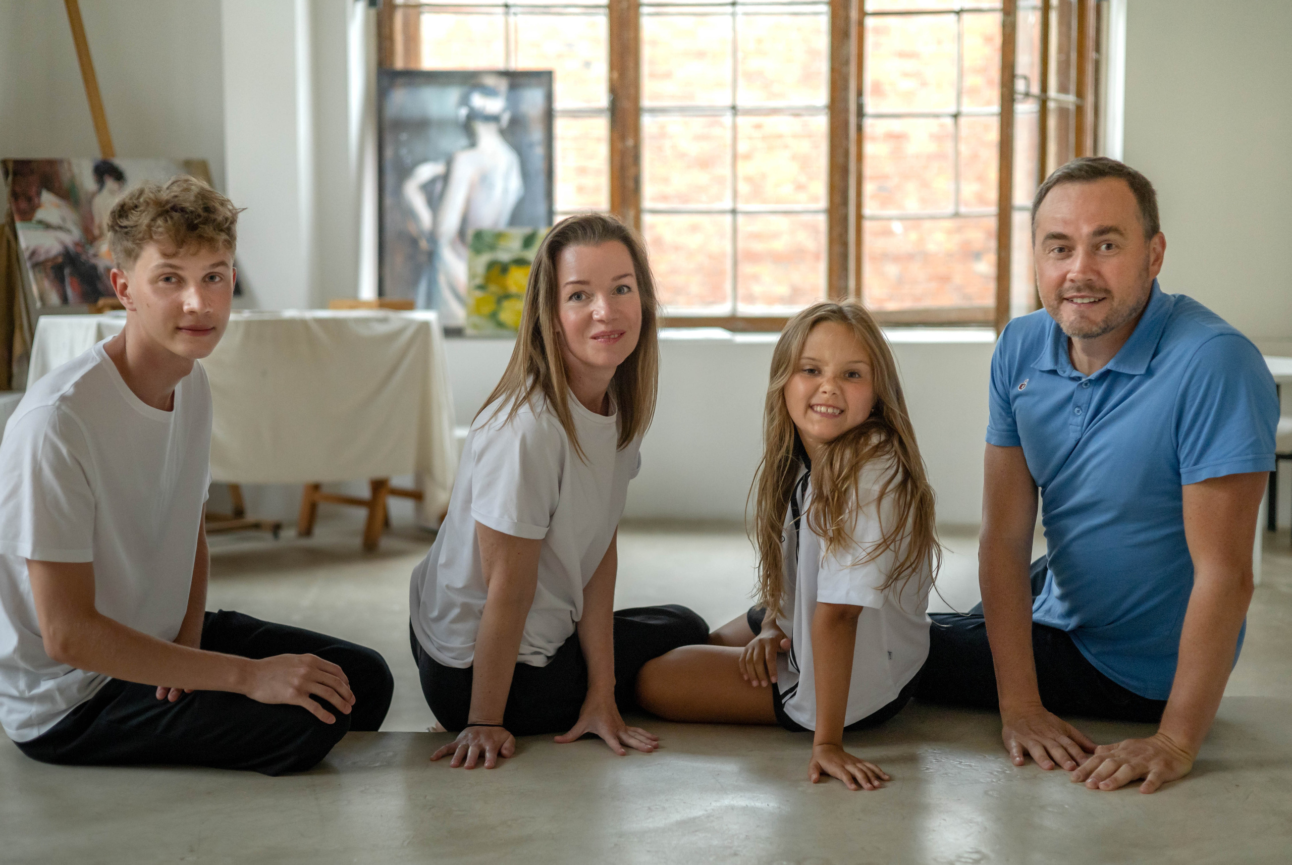 Семья с двумя детьми смотрит в камеру