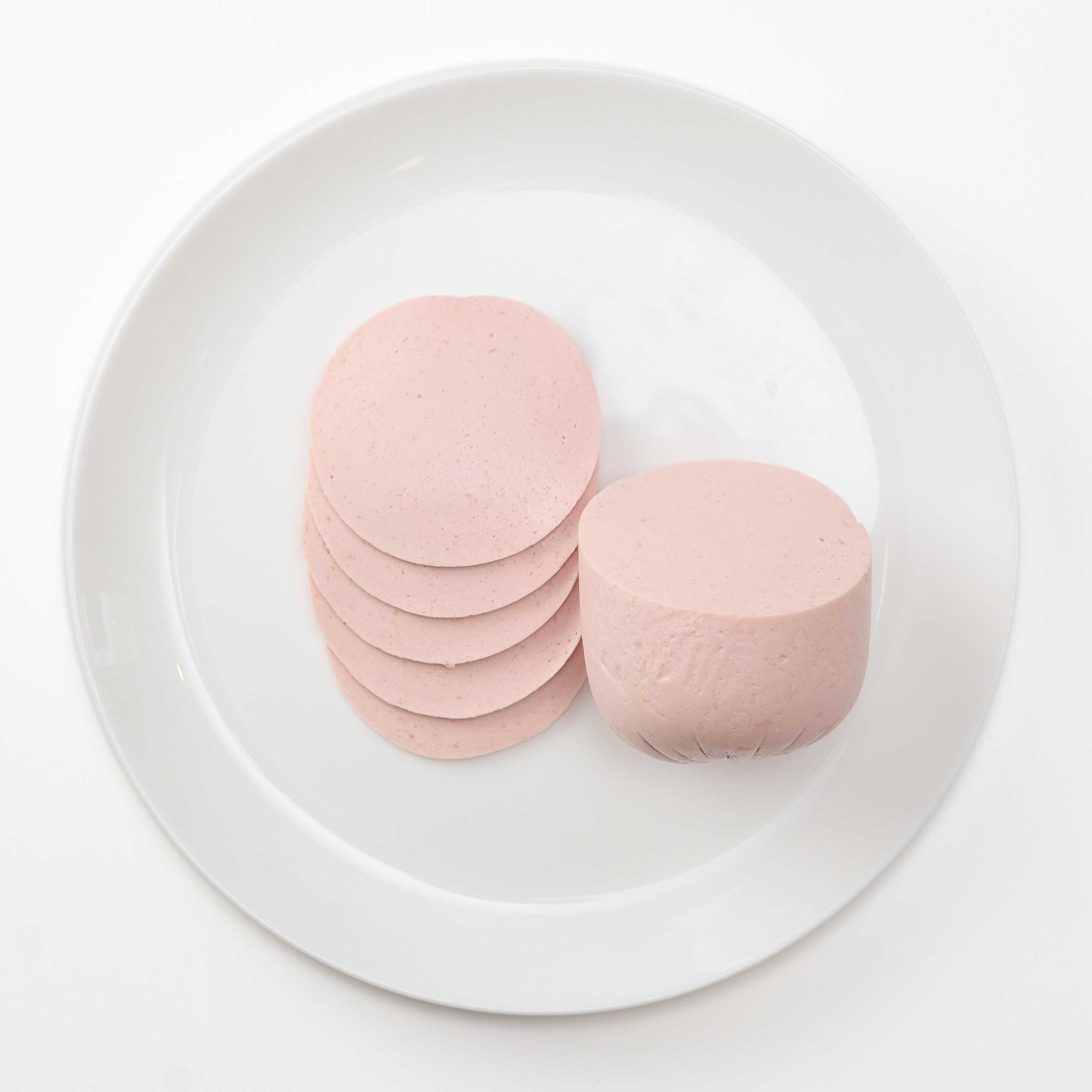 фотосъемка колбасы на тарелке на белой скатерти 