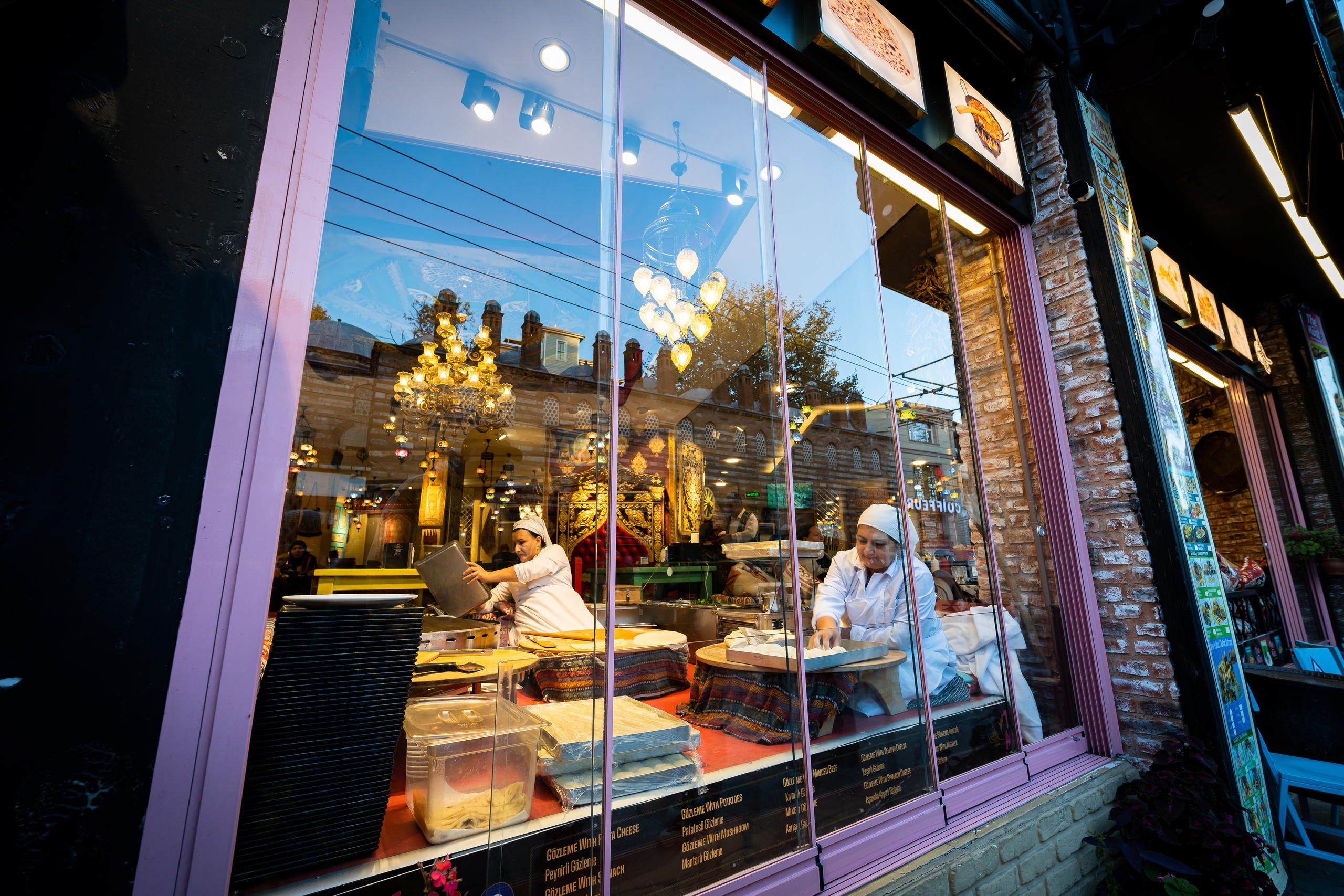 Женщины лепят лепёшки в Стамбуле в окне