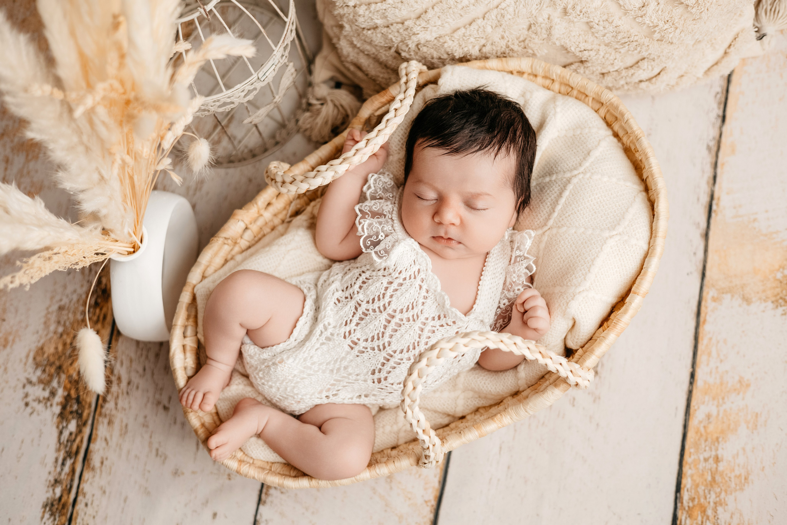 Фотография новорожденного в плетеной корзине с бохо-декором