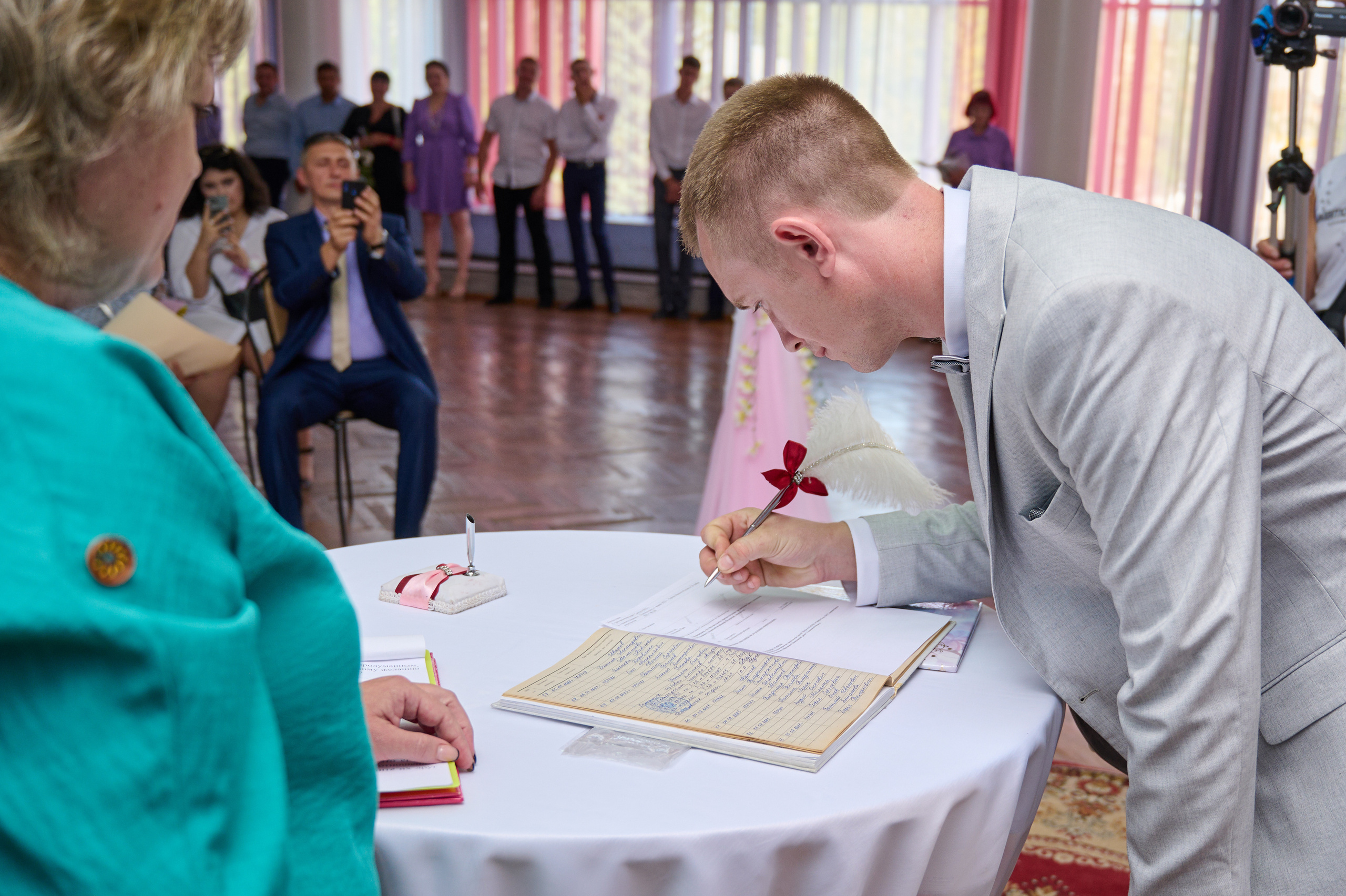 жених расписывается в документах о женитьбе