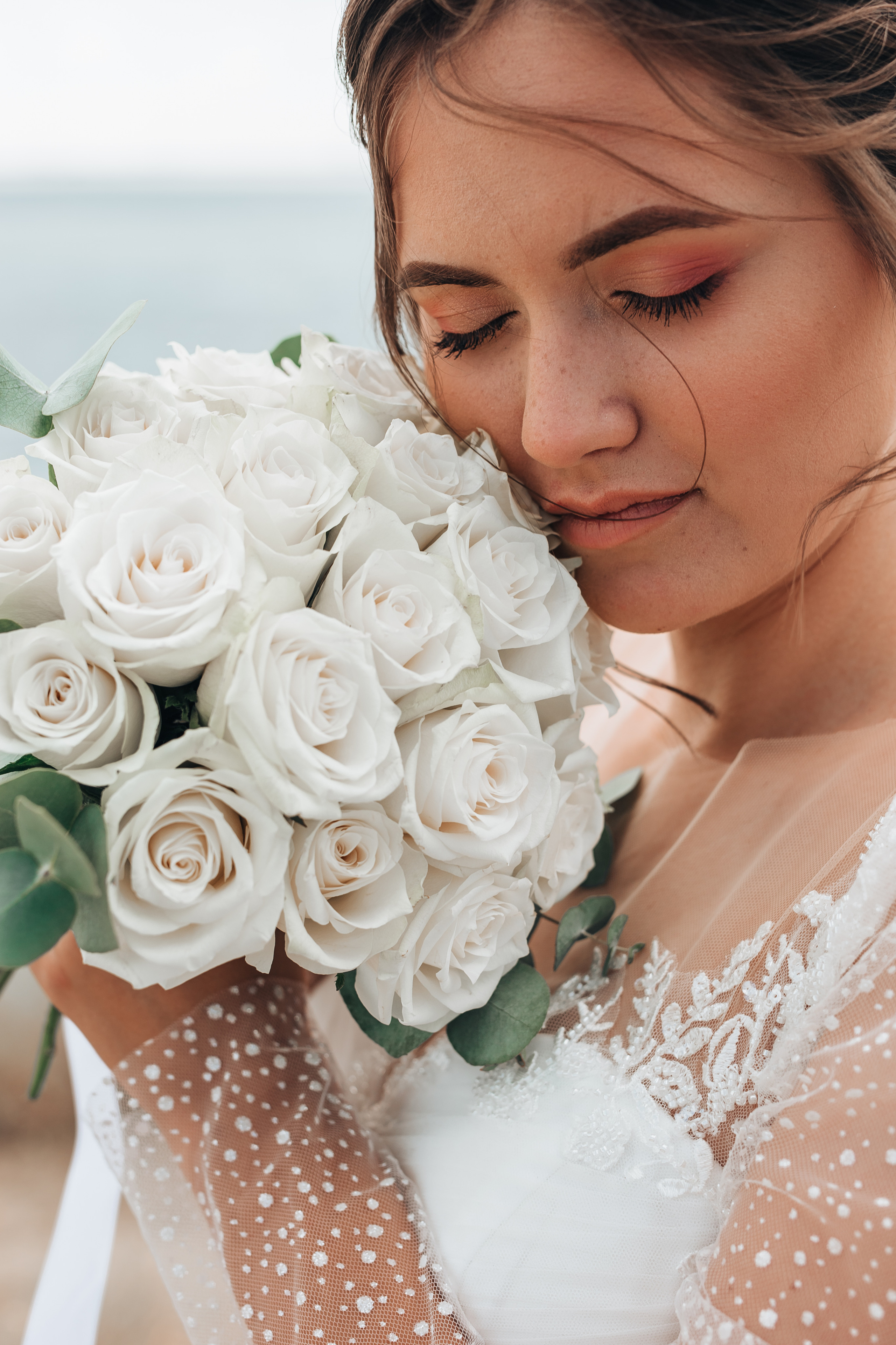 невеста с букетом цветов на фоне моря крупным планом