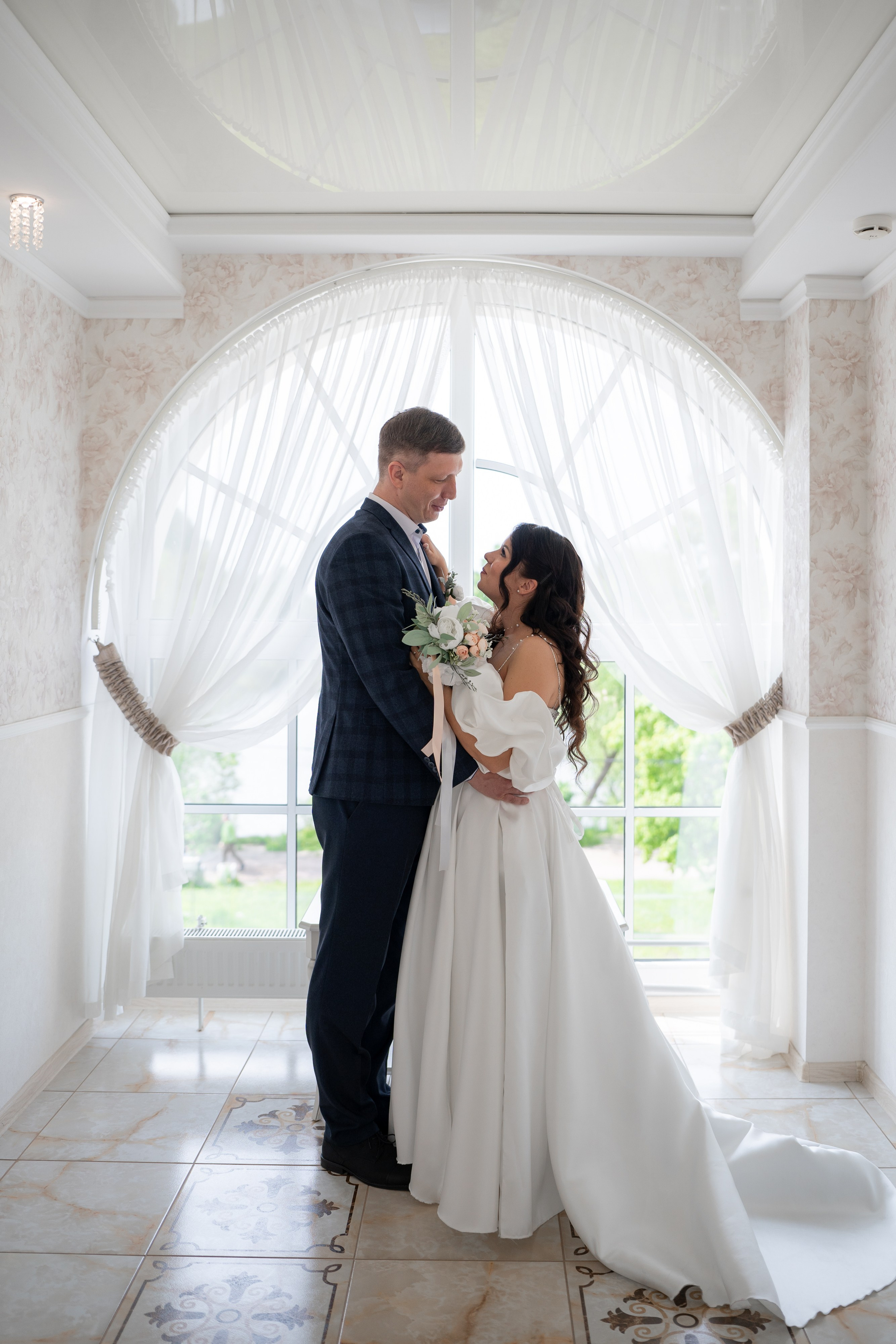 Свадебная фотосессия а загсе Петергофа. Молодые у окна