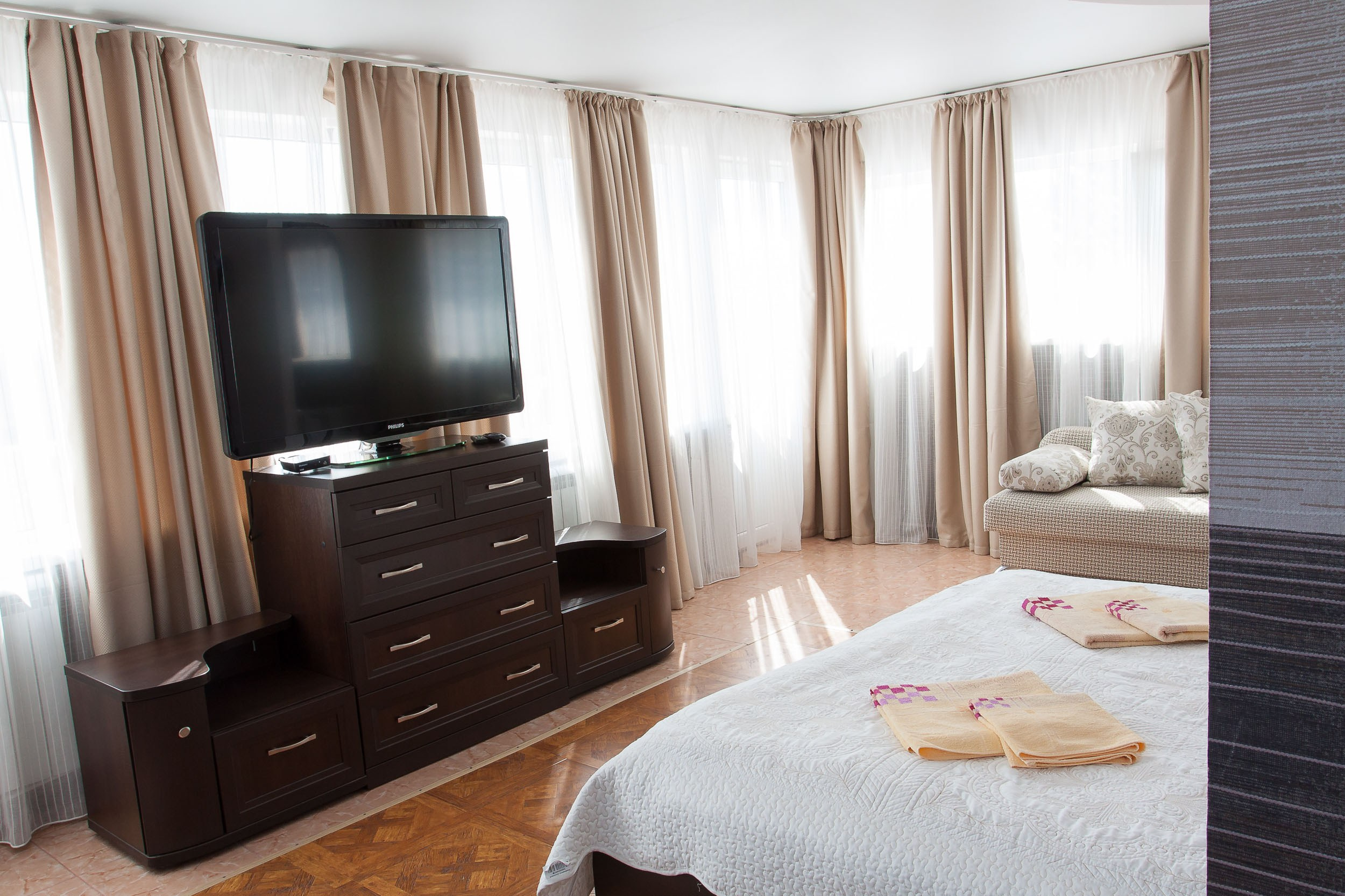 Номер в гостевом доме Горница, интерьер с диваном и телевизором на стене.