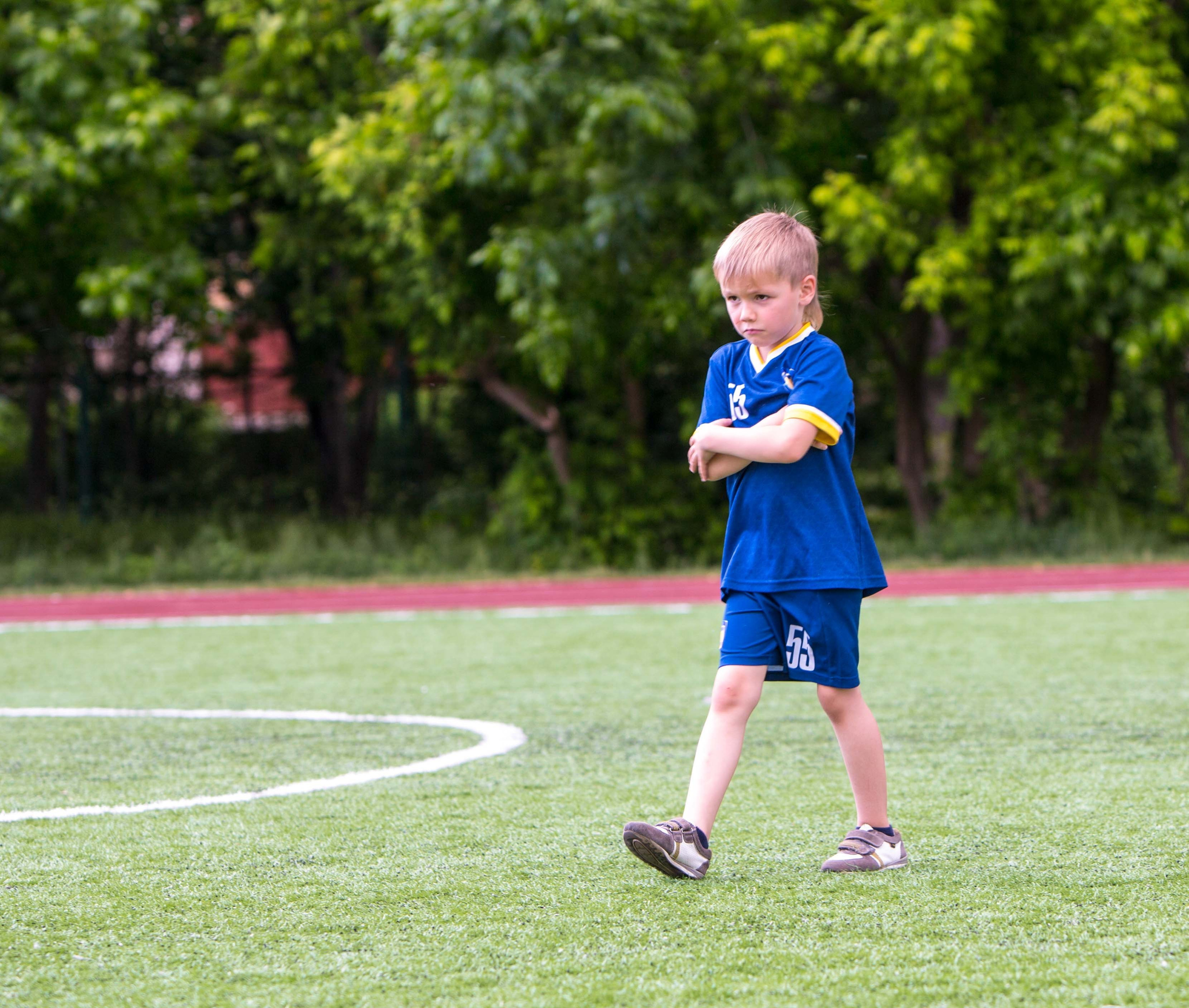 Мальчик ведет мяч, тренер наблюдает за техникой