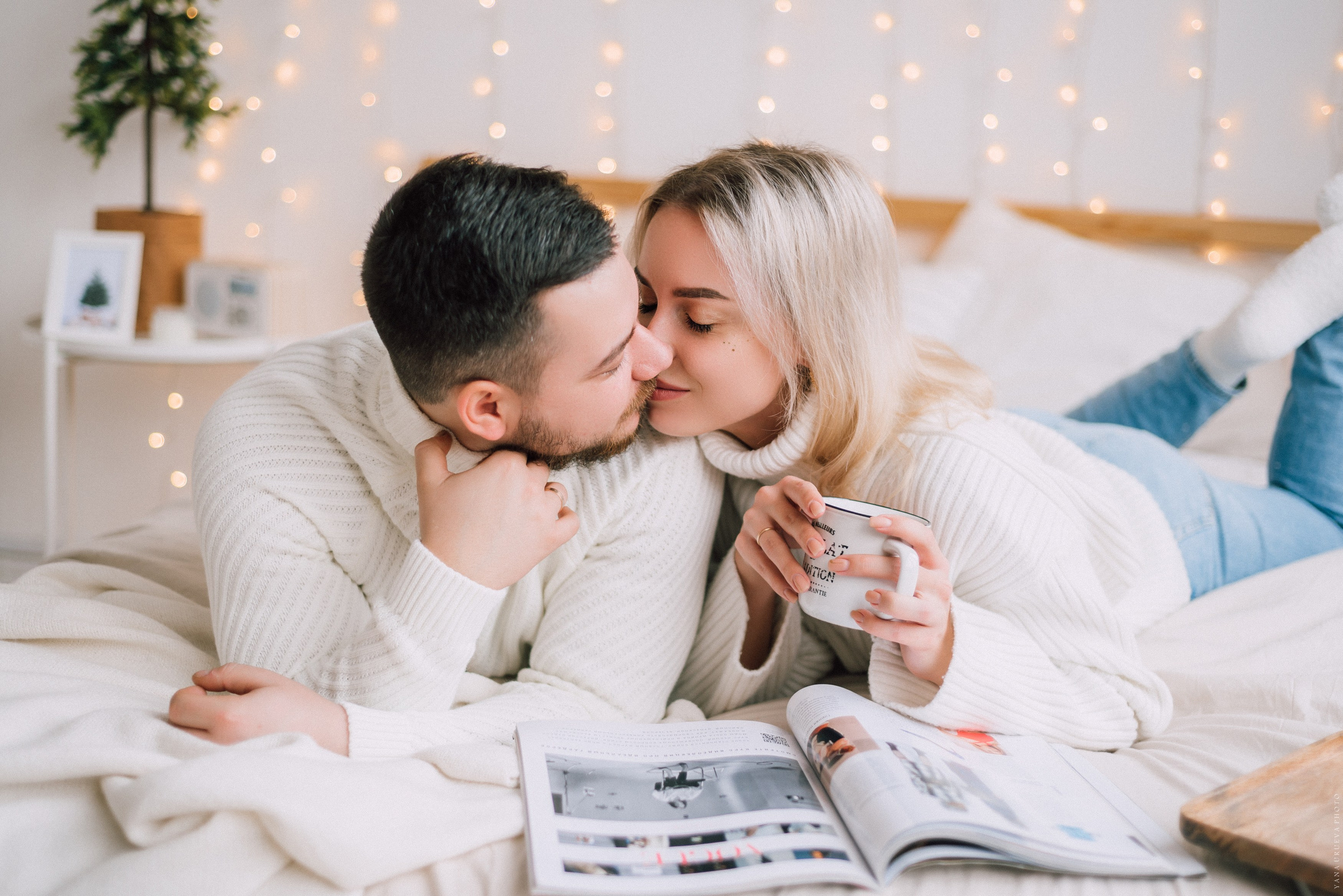 новогодняя лавстори в белых свитерах с чашками кофе