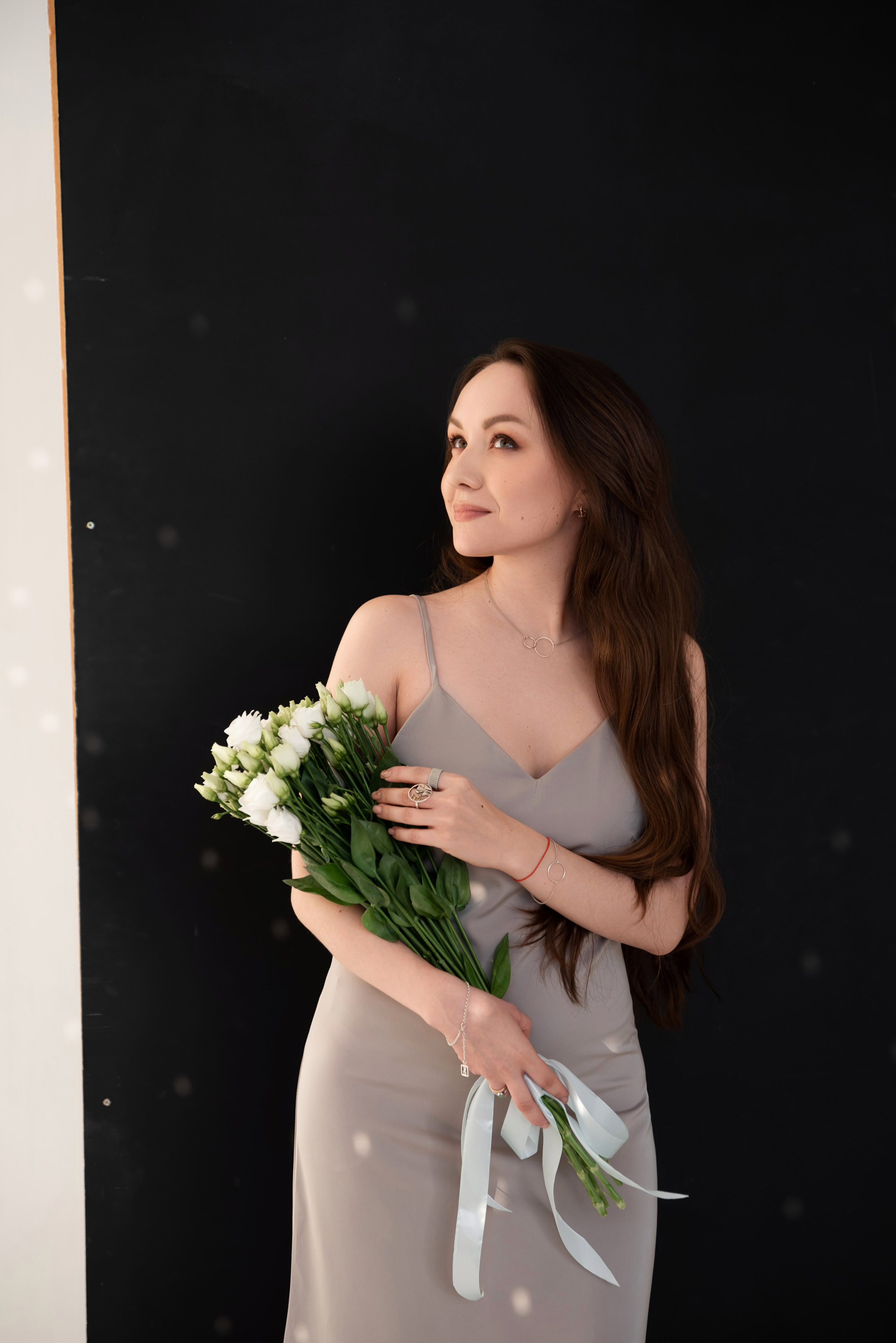 девушка с цветами на черном фоне в фотостудии