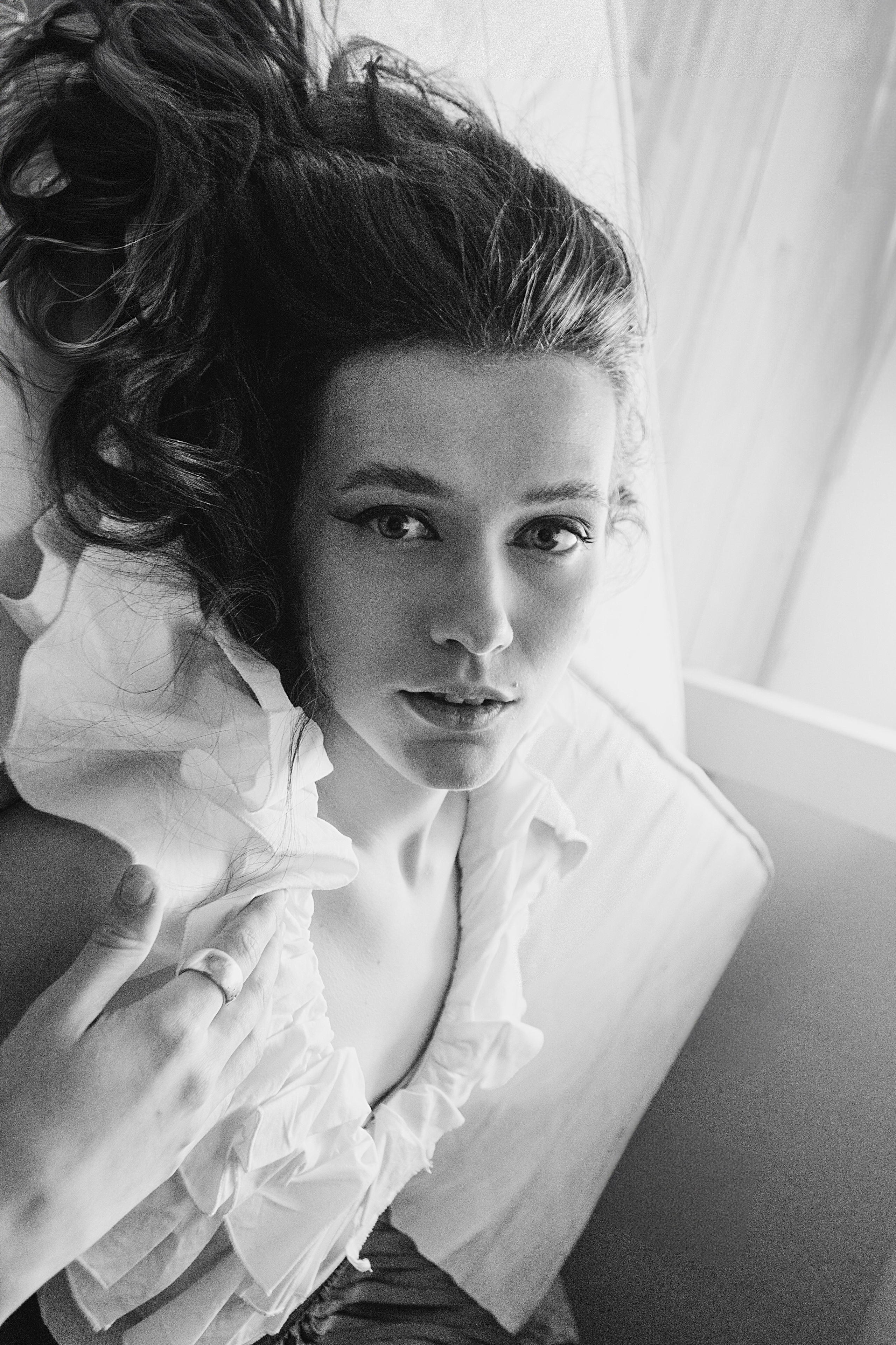 Черно-белая фотография девушки, лежащей на полу и смотрящей на нас