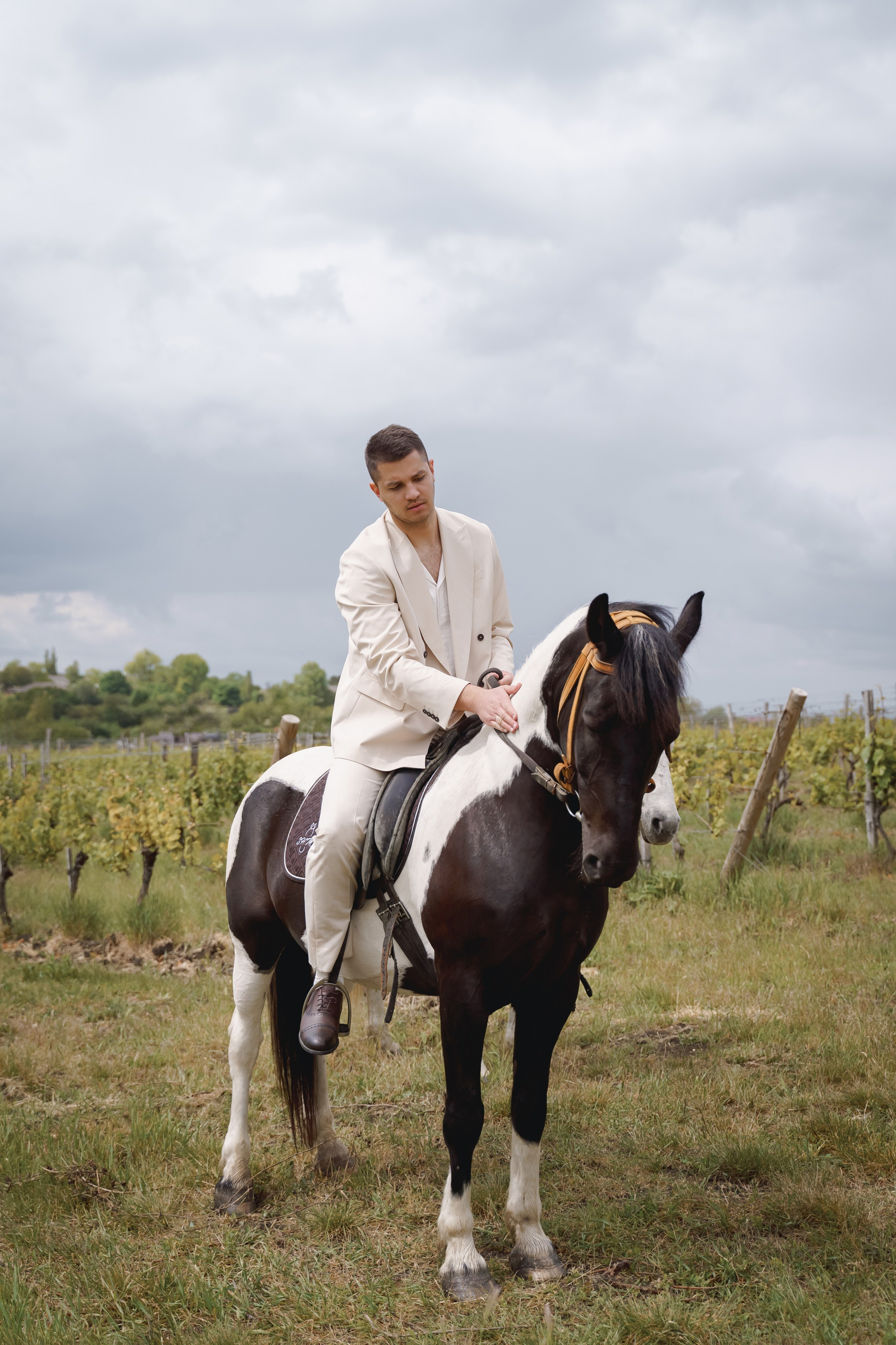 Жених в светлом костюме на коне в виноградниках Анапы