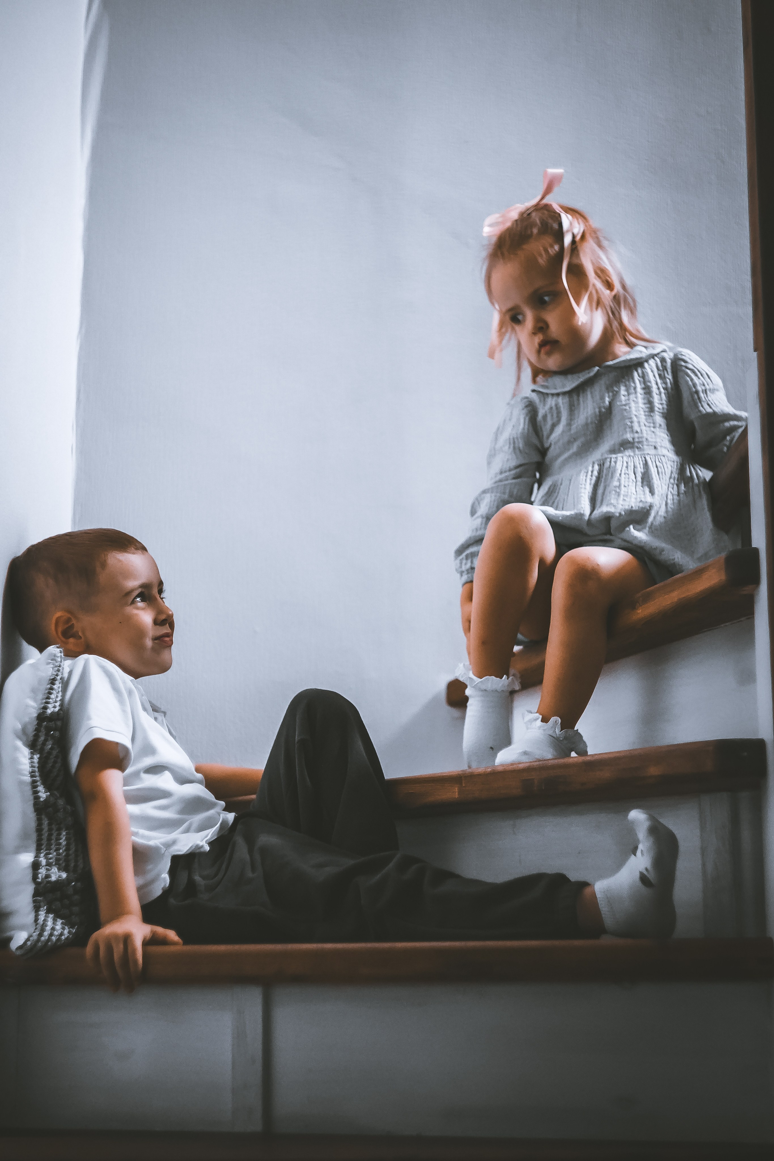 Маленькие брат и сестра сидят на лестнице