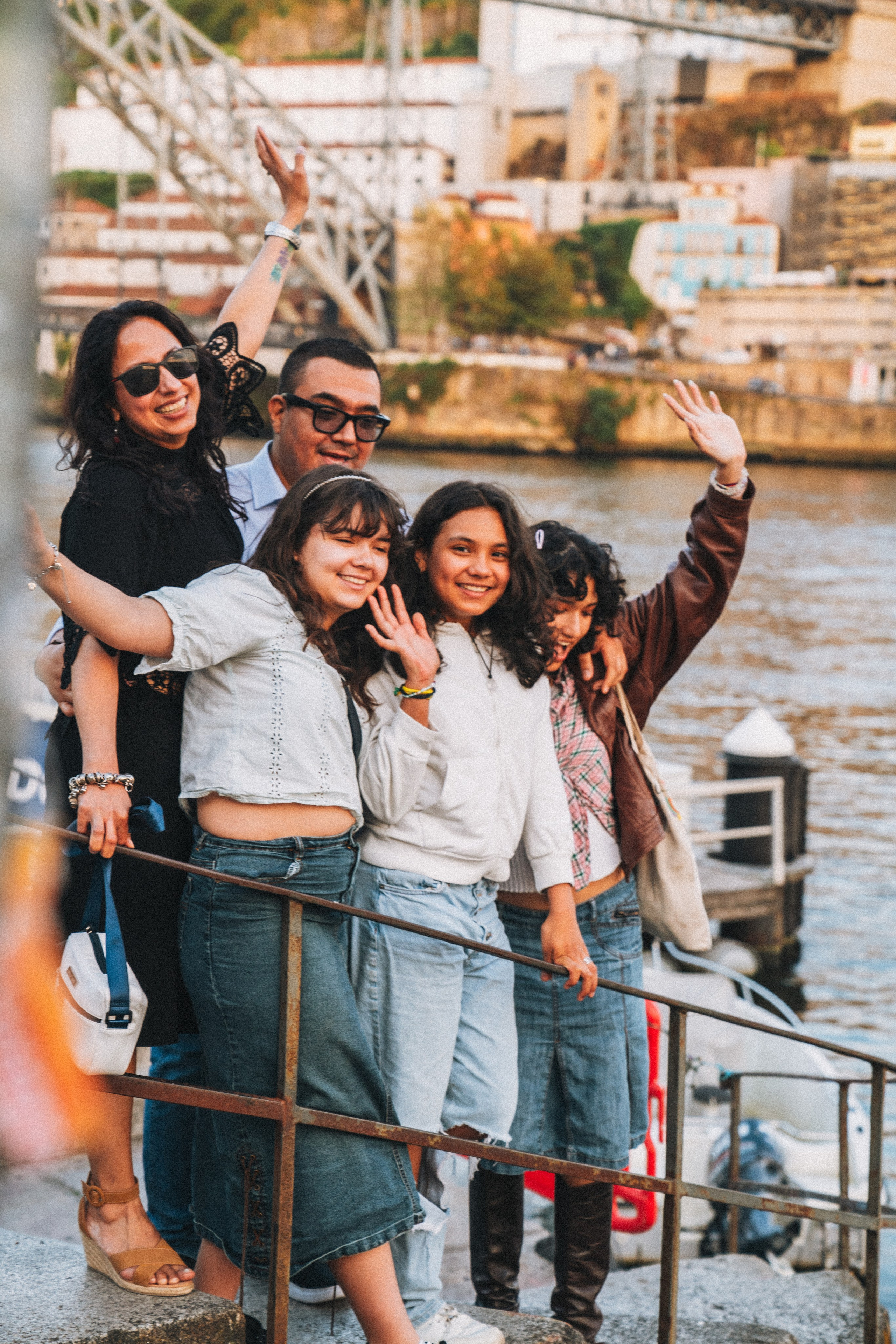 Группа людей семья влюбленные гуляет по живописной узкой улочке в Португалии, окружённой старыми домами и зеленью.