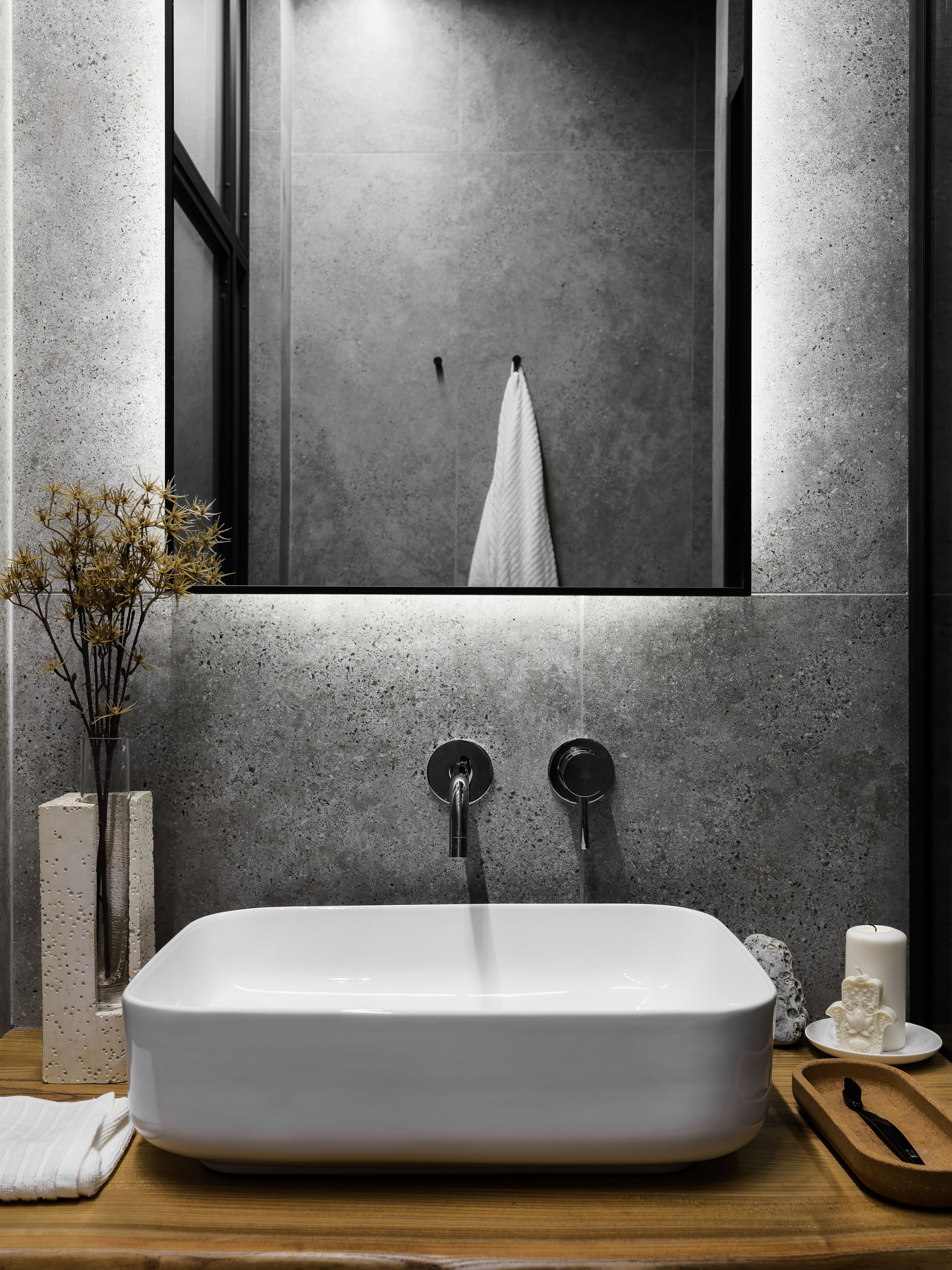 Современная ванная комната в минималистичном стиле с подвесной раковиной, зеркалом с подсветкой и бетонной отделкой стен. Дизайнеры интерьера Андрей Нелень и Екатерина Проскурякова, интерьерная фотосъёмка Сергей Денисенко.