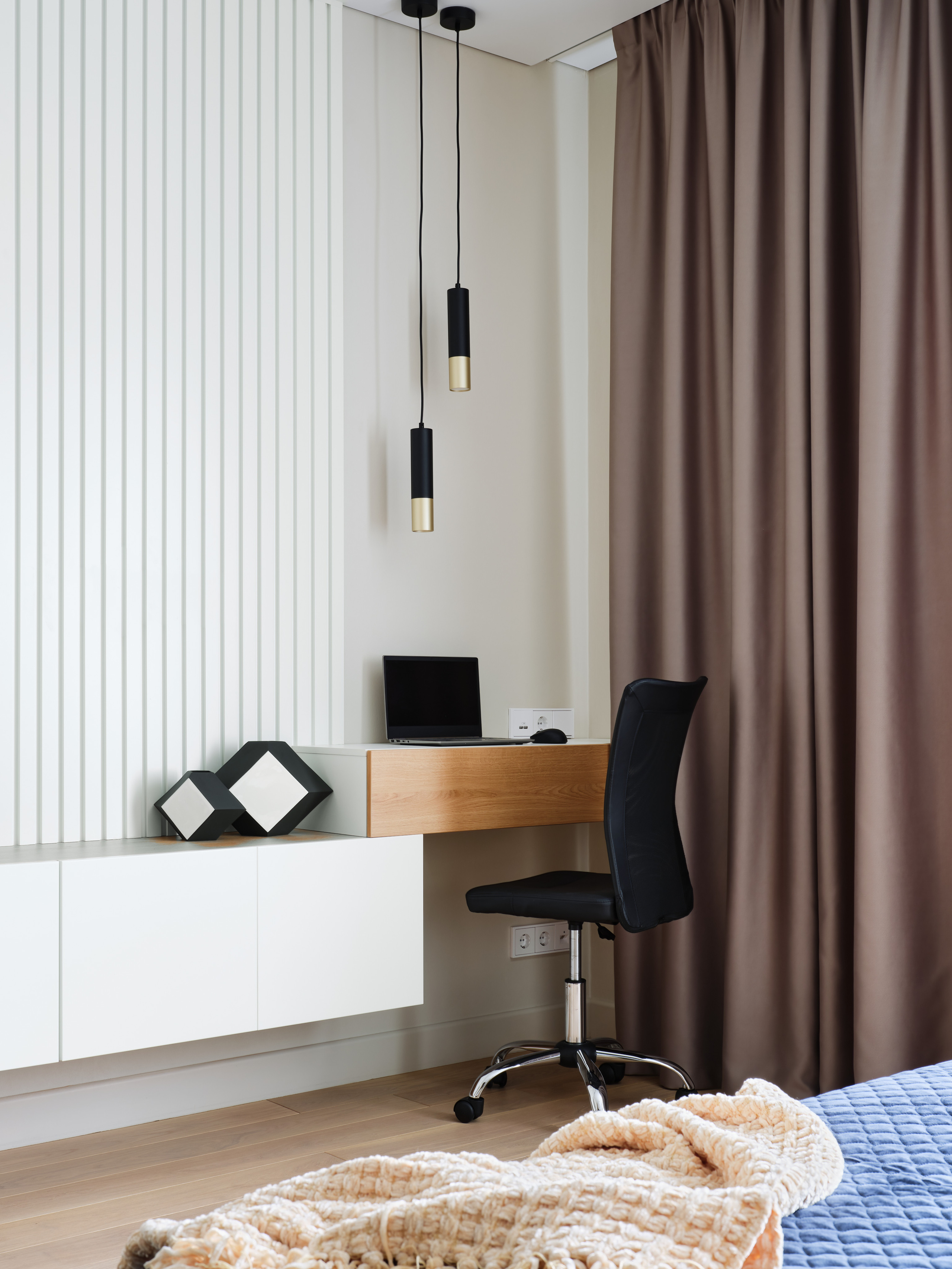 Рабочее место в спальне с подвесными черными светильниками, белыми панелями на стене, столом из дерева и черным офисным креслом. Интерьерный дизайн Анжелика Исаева, фото Сергей Денисенко.