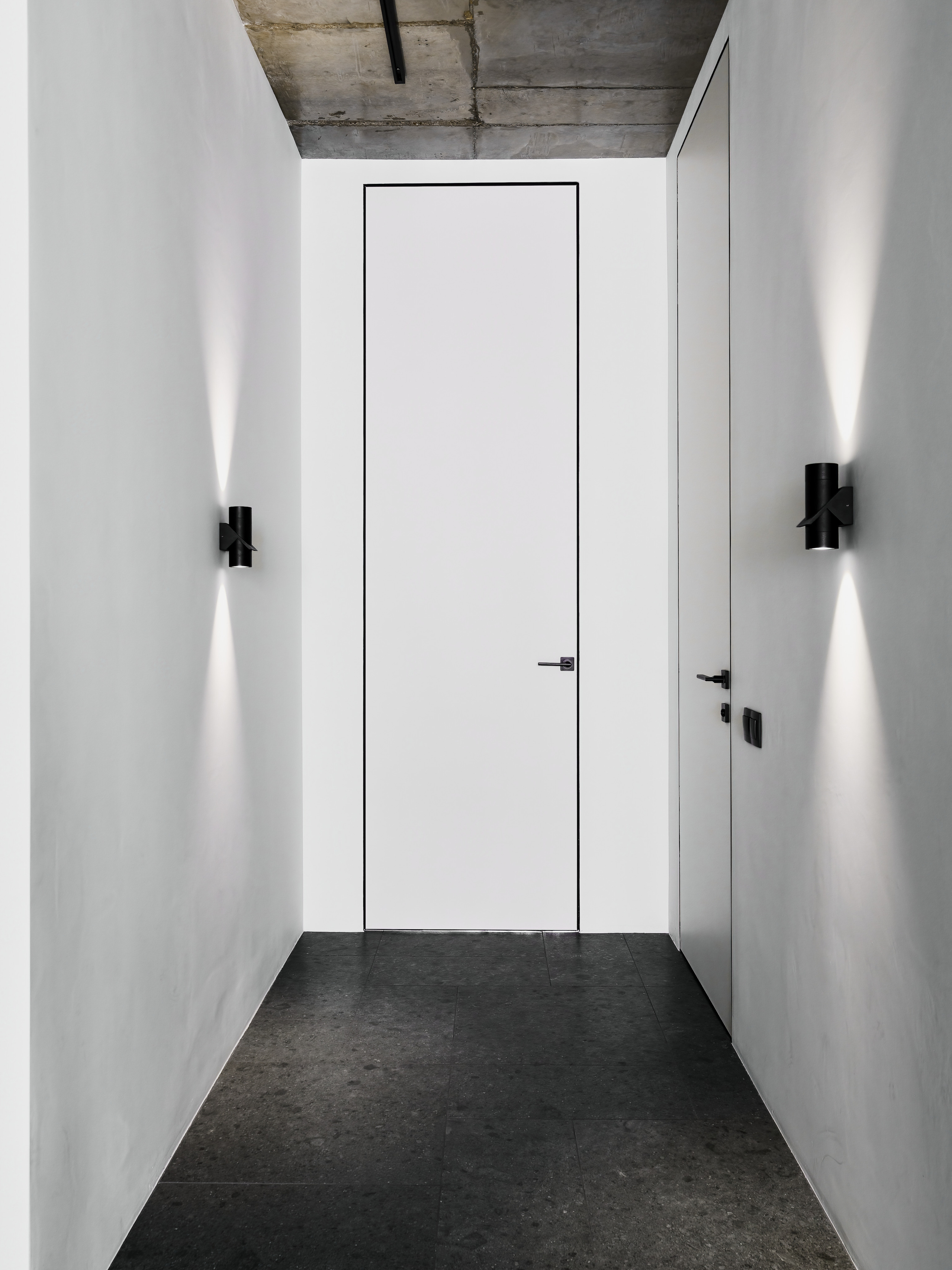 Современный минималистичный коридор с белыми дверями в потолок и встроенной подсветкой на стенах. Дизайн интерьера выполнен Андреем Нелень и Екатериной Проскуряковой, интерьерная фотосъёмка Сергей Денисенко.