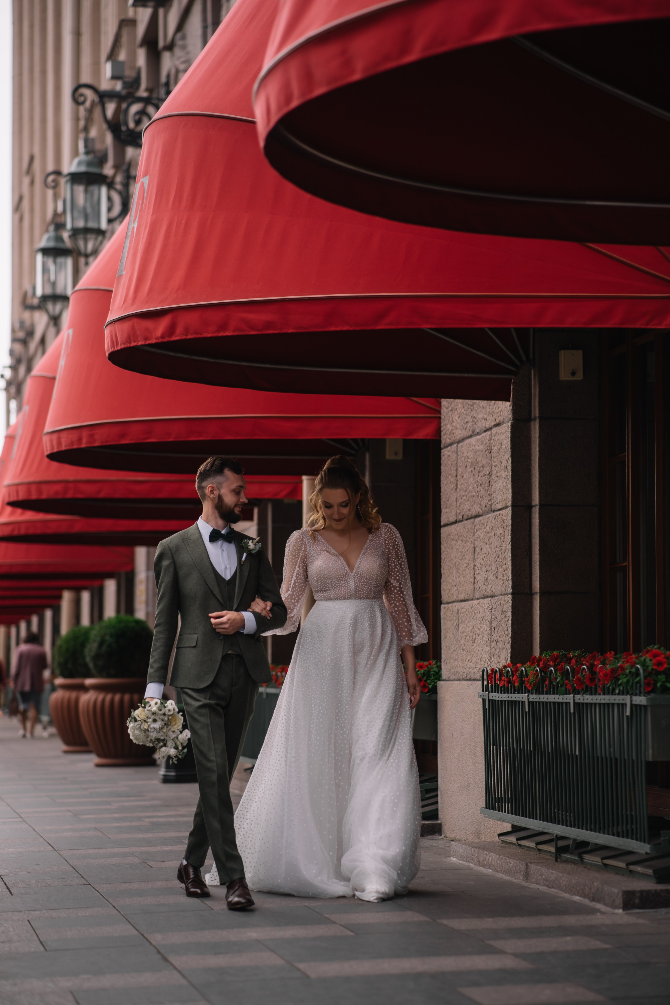 жених и невеста идут под маркизами гостиницы Астория. Свадебная фотосессия у Астории.