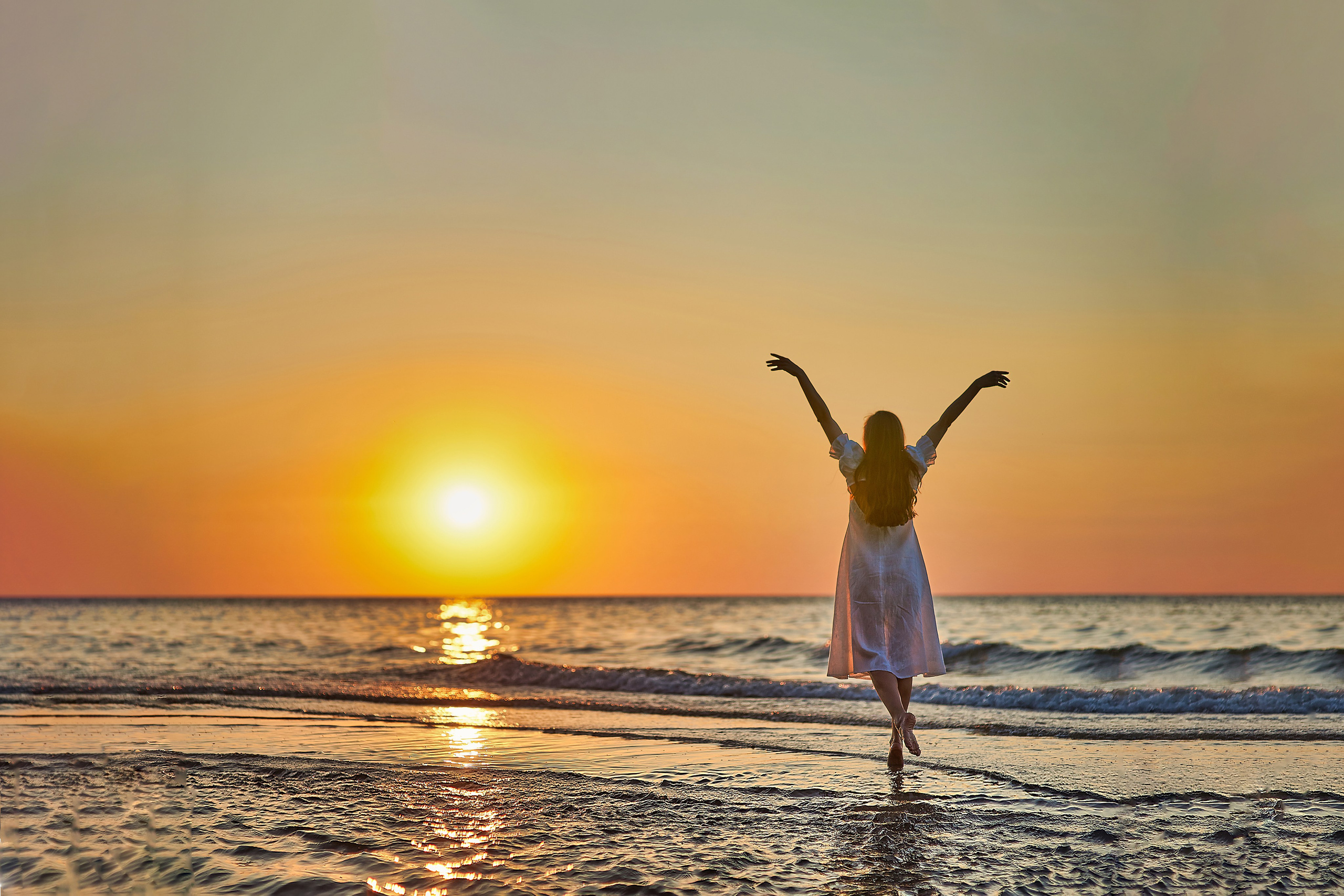 девушка танцует в море на закате