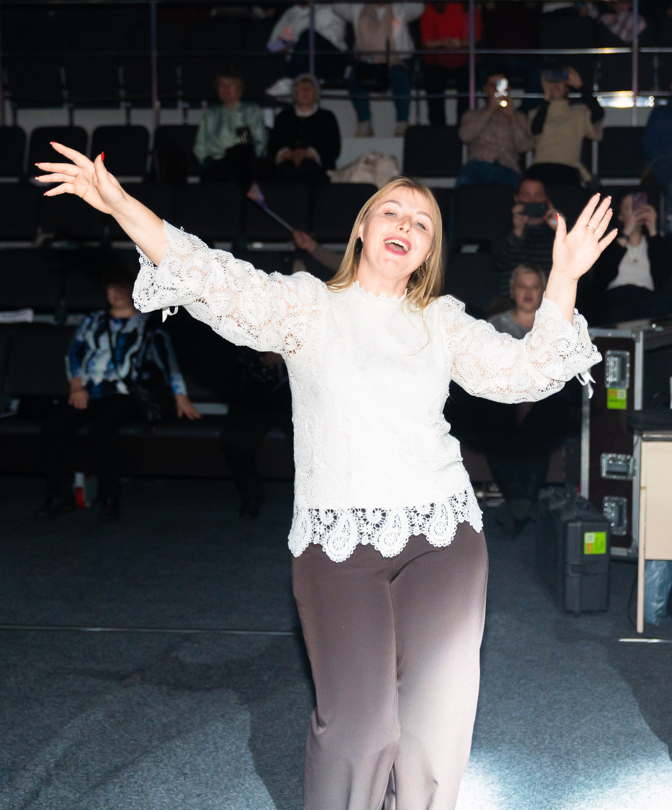 Эмоциональная девушка в белой кружевной блузе танцует на концерте Светланы Разиной. Корпоративный праздник Ленремонт в КСК Арена. Фото Евгения Мальцева.