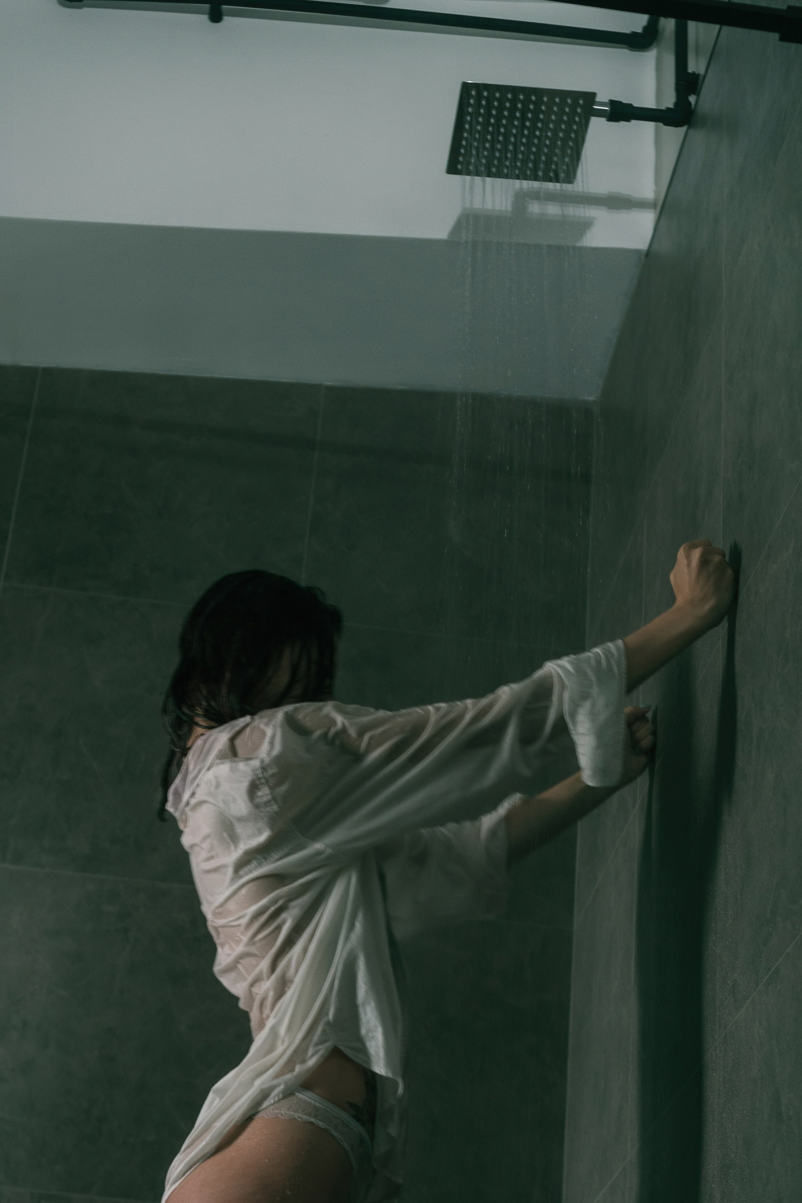 Девушка в душе, сверху льётся вода.