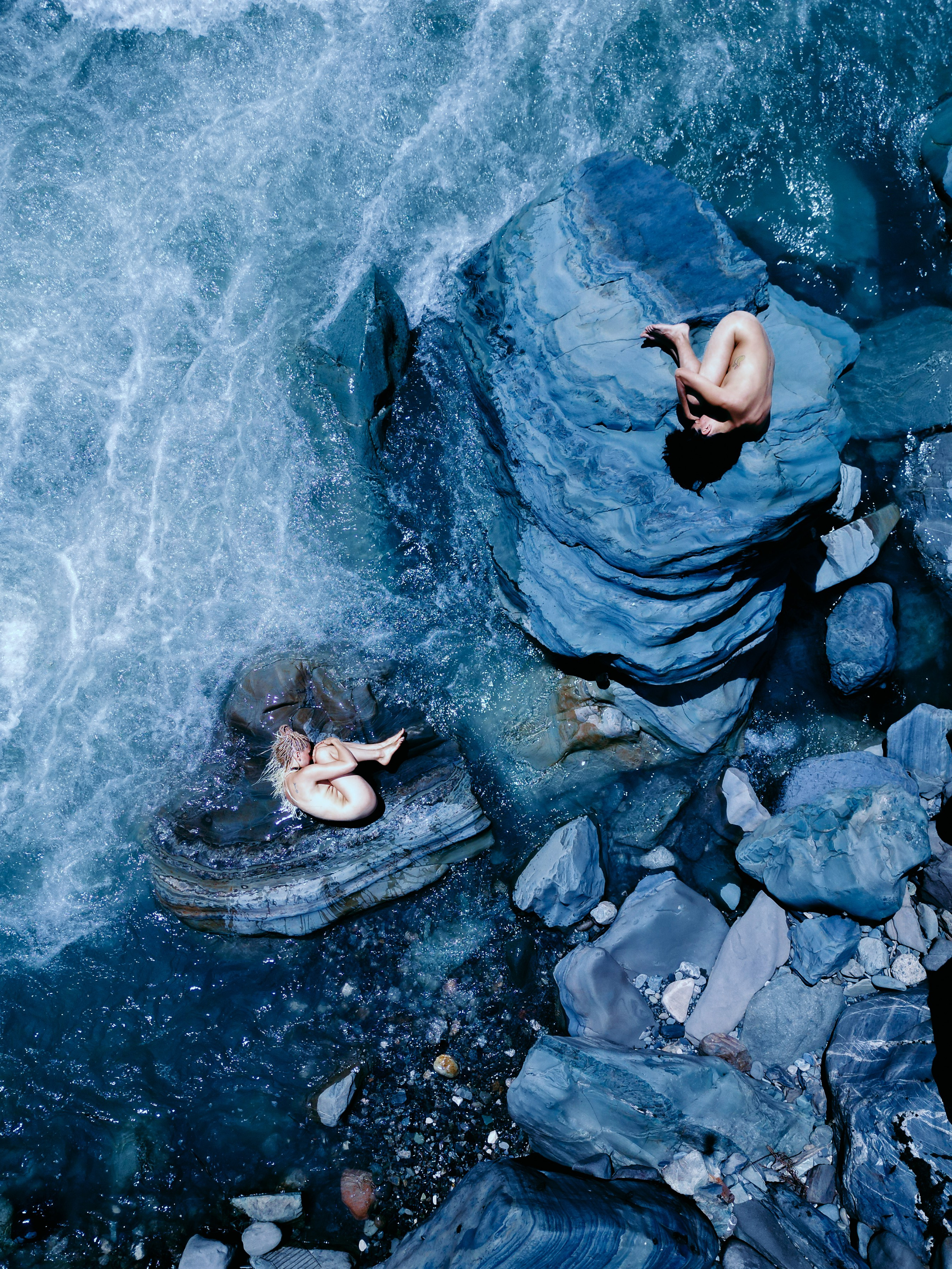 Фотоснимок двух девушек с дрона сверху на камнях в стиле НЮ