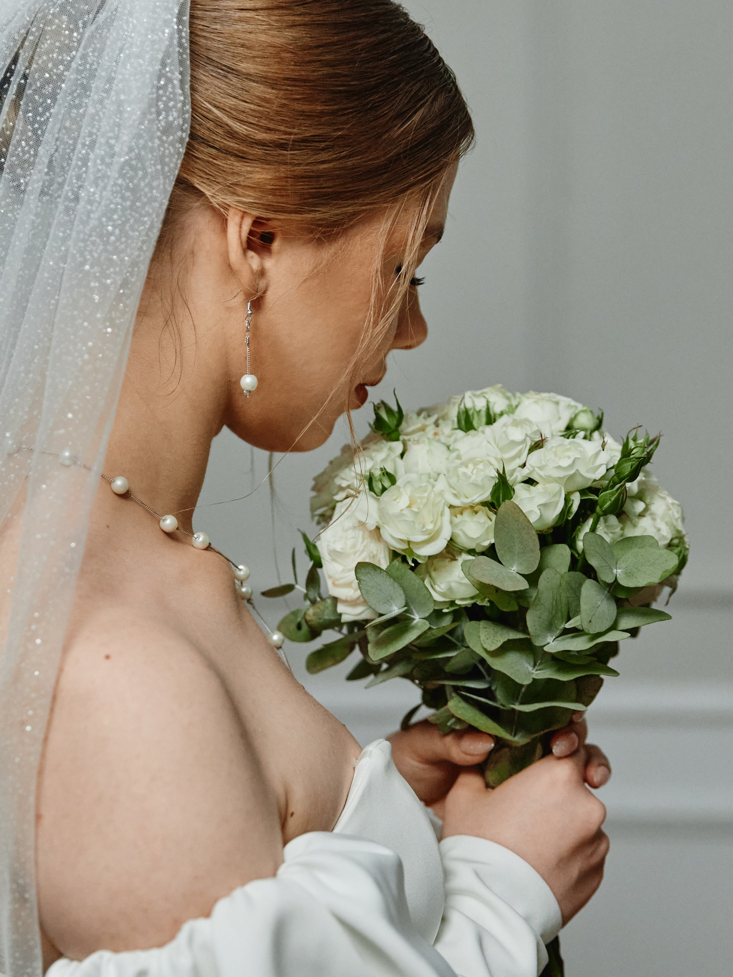 Невеста в фоте нюхает букет 